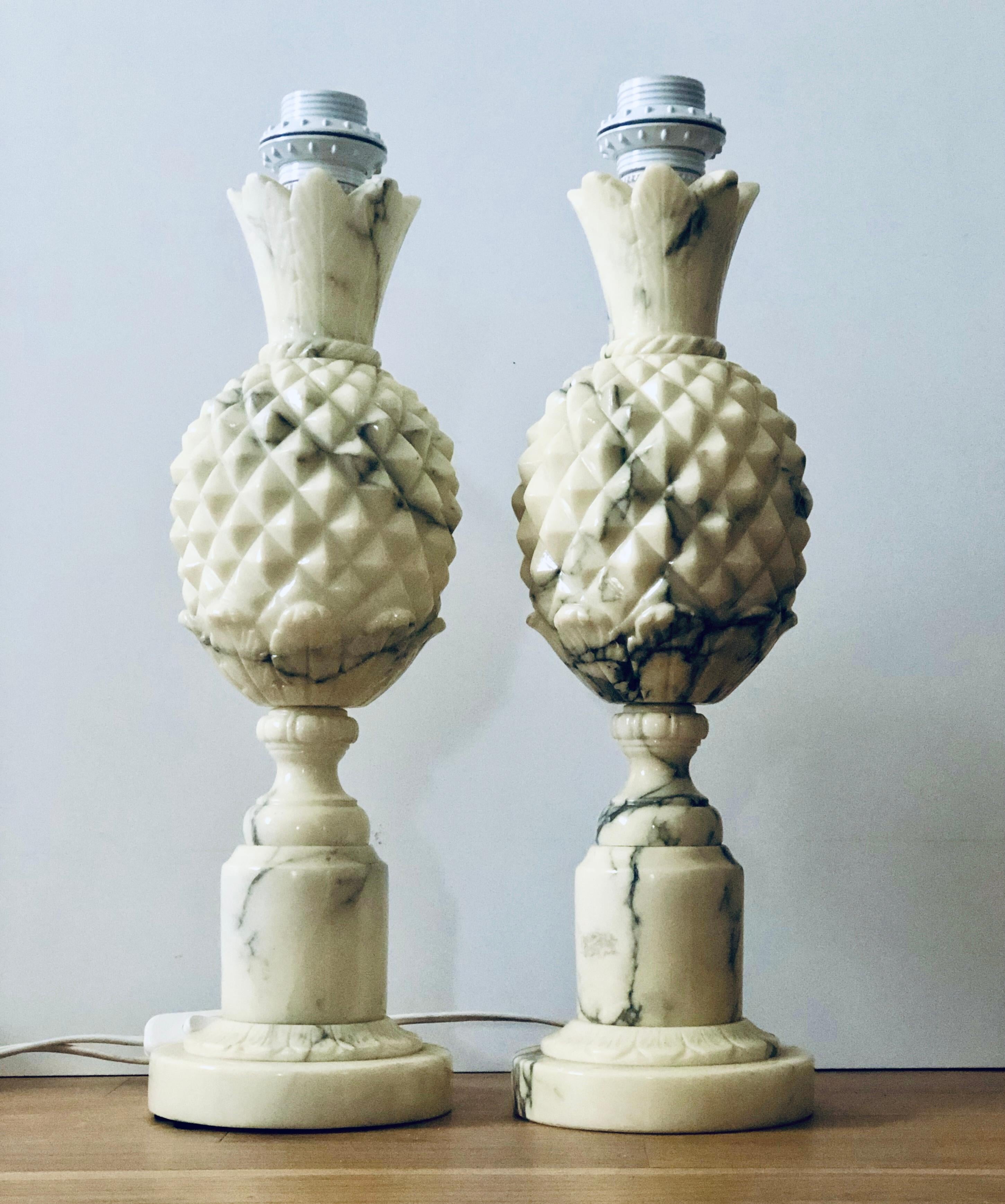 Pair of midcentury Italian table lamps. The lamps are made of marble stone carved in shape of pineapples and have a warm shade of white/grey marble. Good original vintage condition. Origin unknown. Lamps are wired with white cord with flat EU plugs.