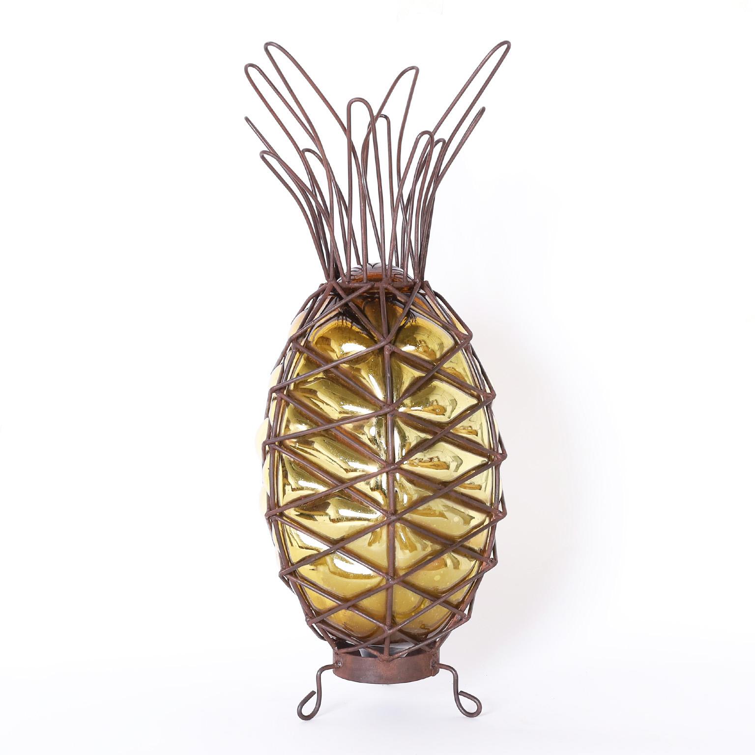 Standout pair of decorative pineapples hand crafted with a stylized metal frame having gold tone mercury glass blown into it.