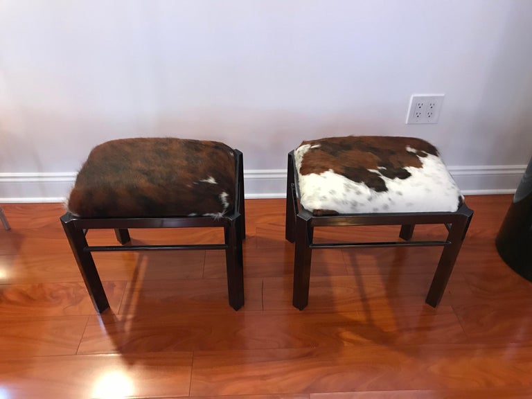 Beautiful pair of Mid-Century Modern benches upholstered with cow hide. With black metal frame and upholstered cowhide top.