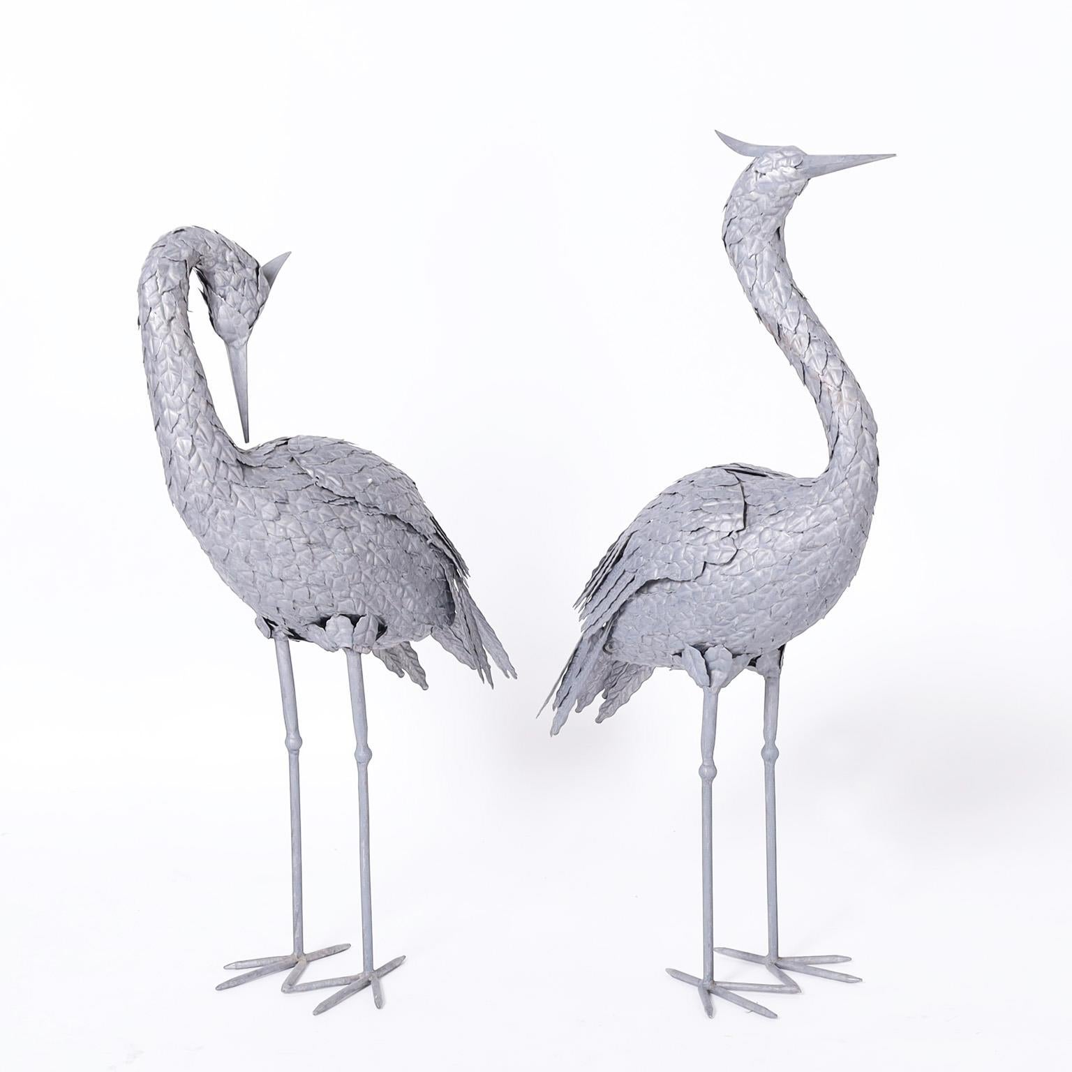 Standup pair of life size mid century cranes hand crafted in metal, each with its own familiar stance and chic raw metal finish.

Left H: 29 W: 17 D: 7
Right H: 32 W: 20 D: 7.
