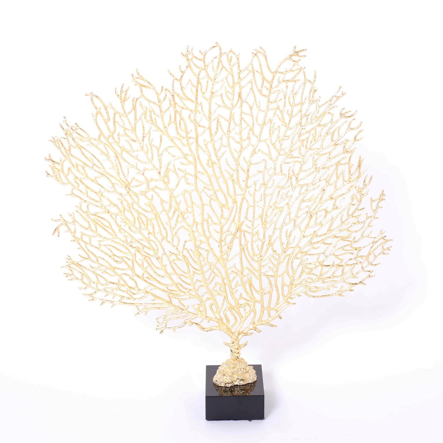 Drammatica coppia di ventagli in metallo fuso della metà del secolo scorso con la loro forma iconica rifinita in foglia d'oro e presentata su basi in vetro nero.