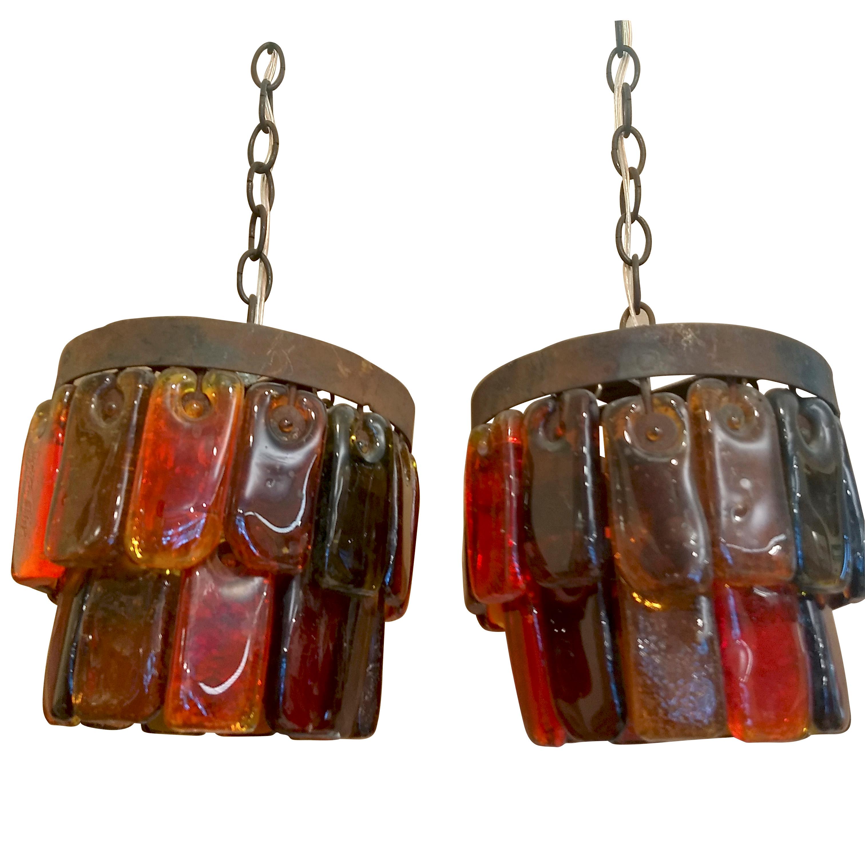 Beautiful pair of pendant lights with two tiers of hand made rectangular glass pieces in assorted colors each, attached to two concentrical iron rings (hold by a chain). The look of the metal is rusty and combines well with the ochre, yellow, orange