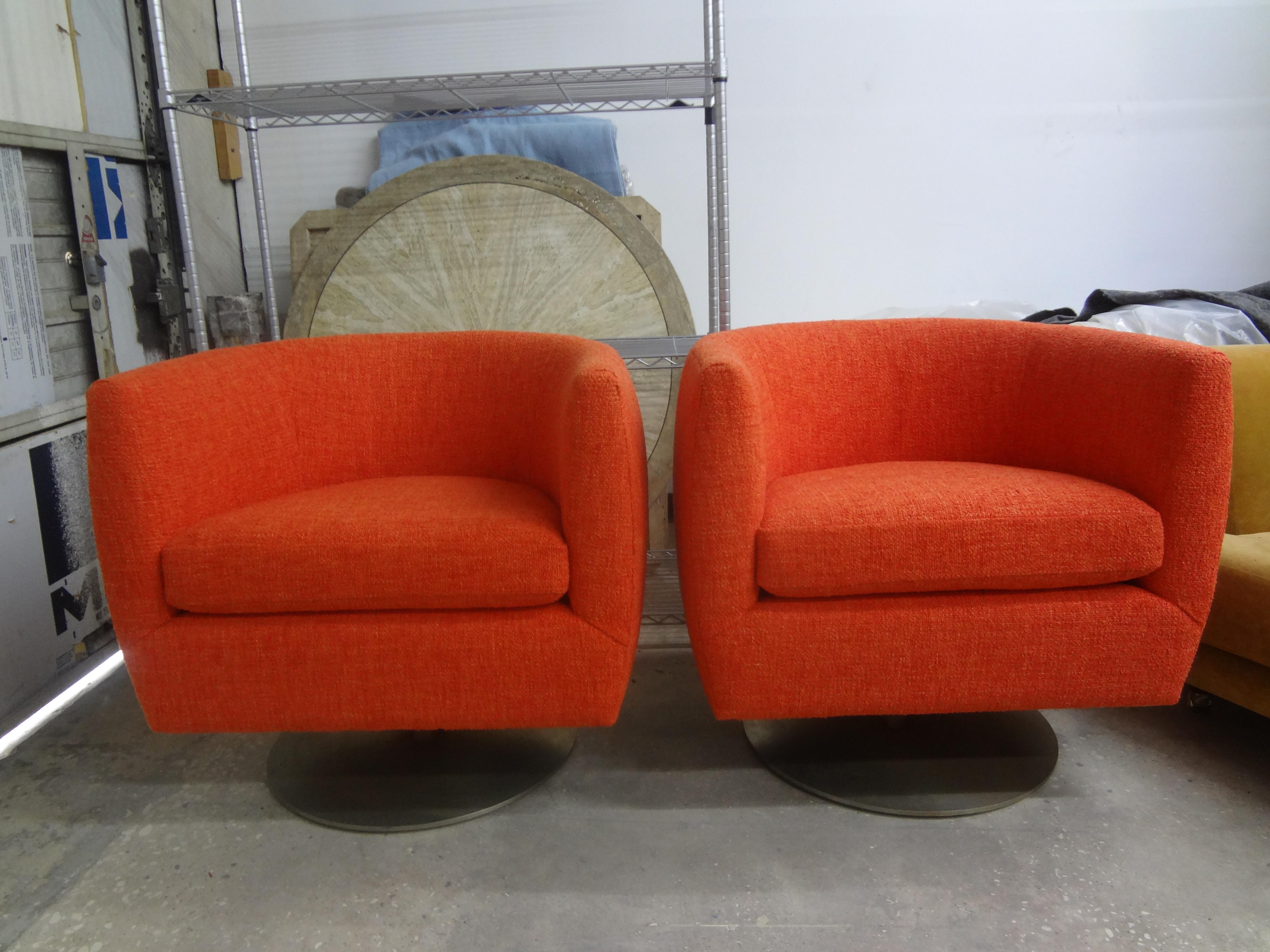 Stunning comfortable pair of Mid-Century Modern Vladimir Kagan style barrel back swivel chairs. These beautifully constructed Vladimir Kagan-Milo Baughman style swivel chairs have a very heavy steel base and have been newly upholstered in orange
