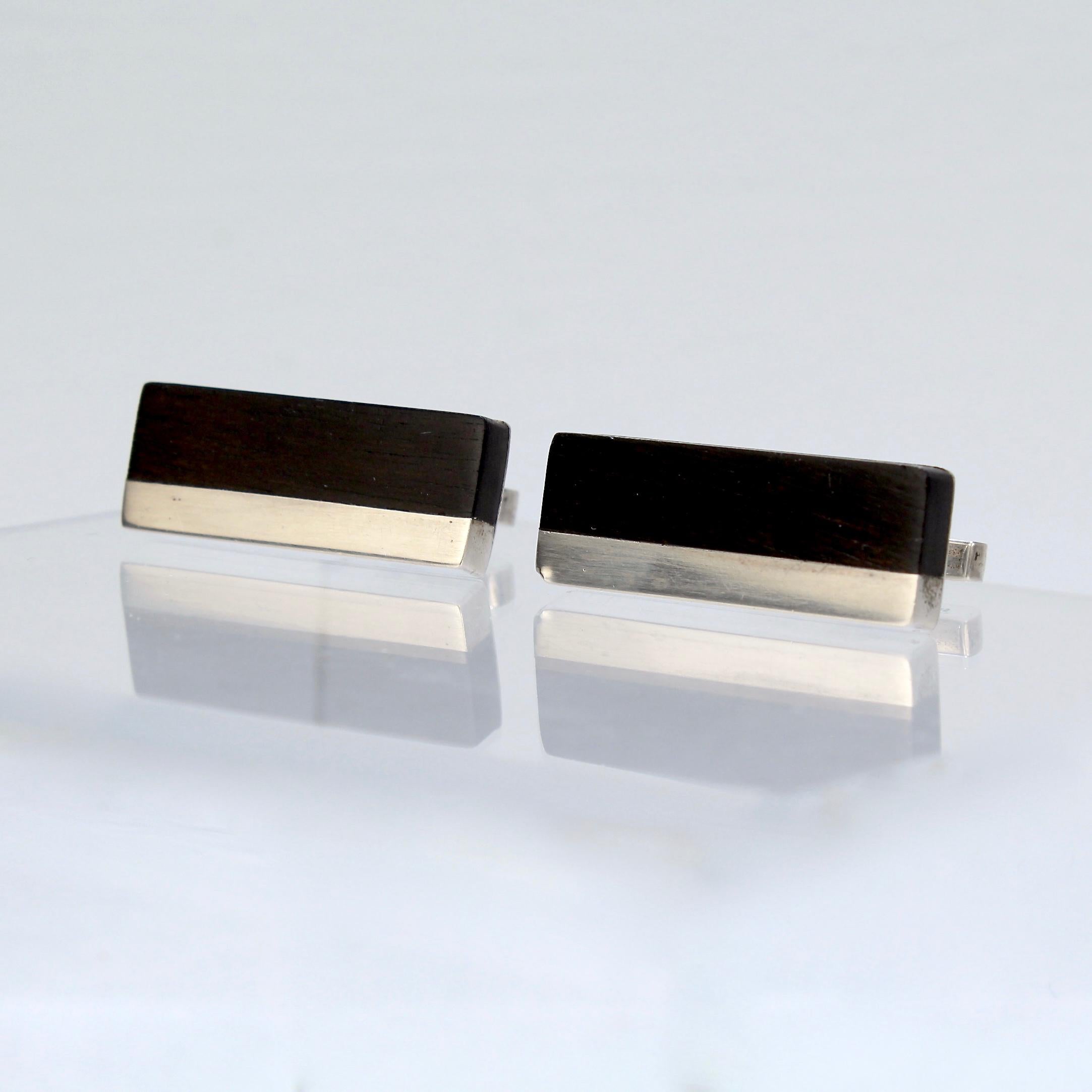 A fine pair of Milton Cavagnaro cufflinks.

In sterling silver with inlaid ebony.

Marked: Sterling for silver fineness and Cavagnaro.

Great cufflinks from the renowned California (Bay Area) Mid-Century artist and jewelry maker!

Width: ca.