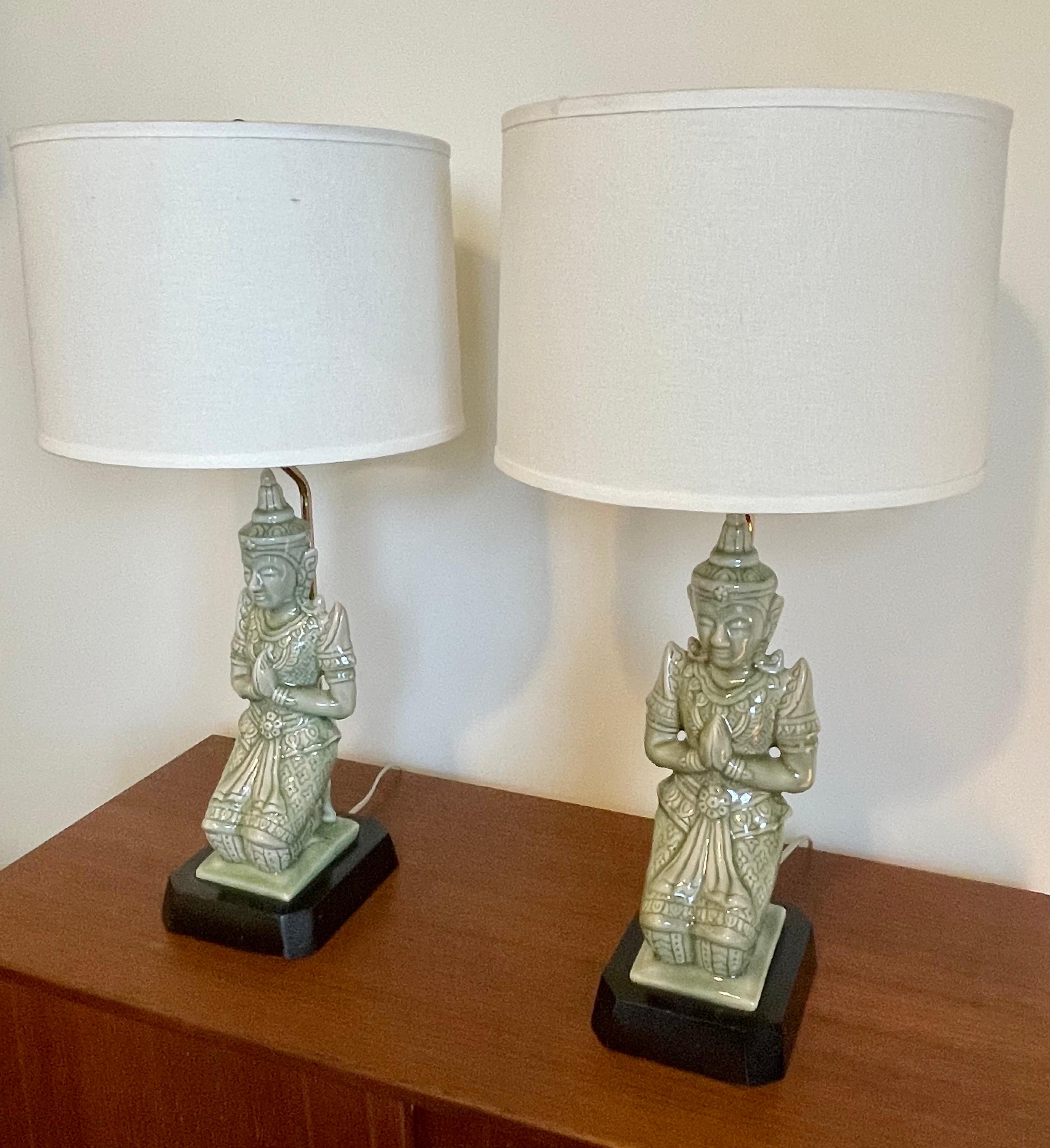 Fantastic pair of mid-century seated Buddha table lamps, beautiful soft mint green porcelain, professionally rewired and shades are included. Measures: 24.50 inches to top of shade, 20' top of socket.