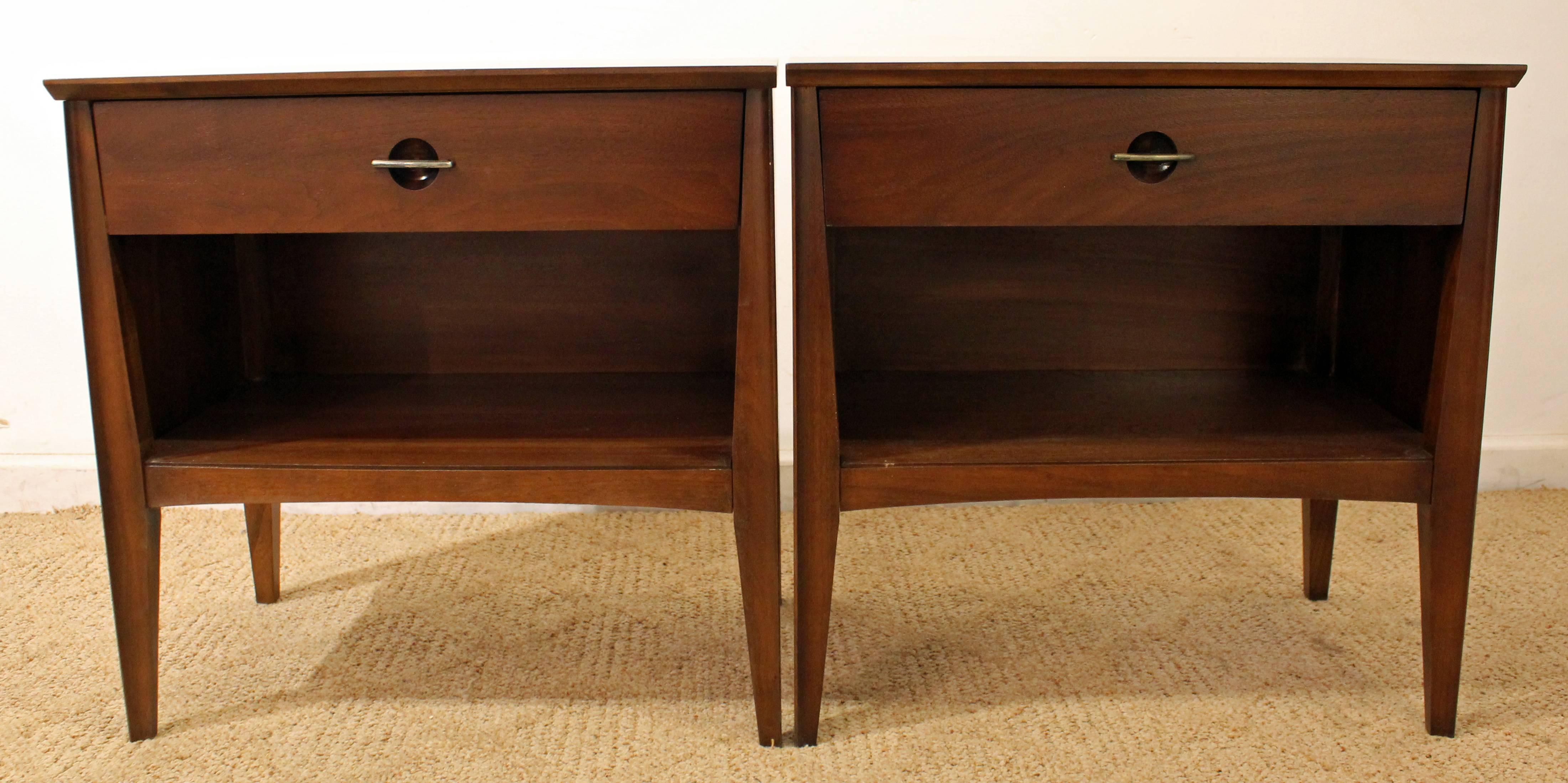 These nightstands have been refinished with a walnut stain and feature one dovetailed drawer each with metal pulls.