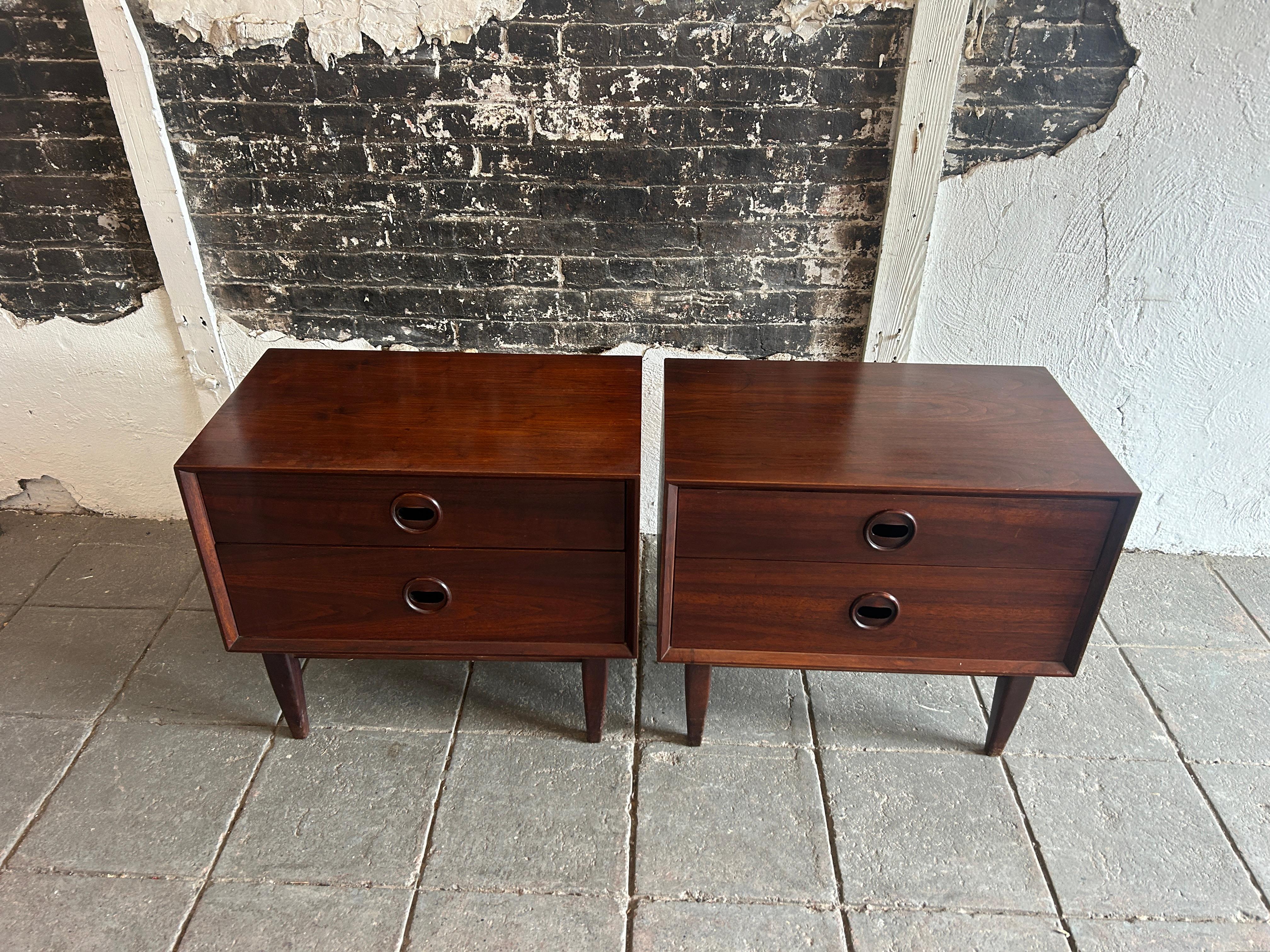 Pair of unique mid century modern walnut nightstands with carved handles. Dark reddish walnut wood Danish rosewood style with circular eye carved handle / Pulls. Dovetail solid oak drawer construction. Made in USA circa 1960. Located in Brooklyn