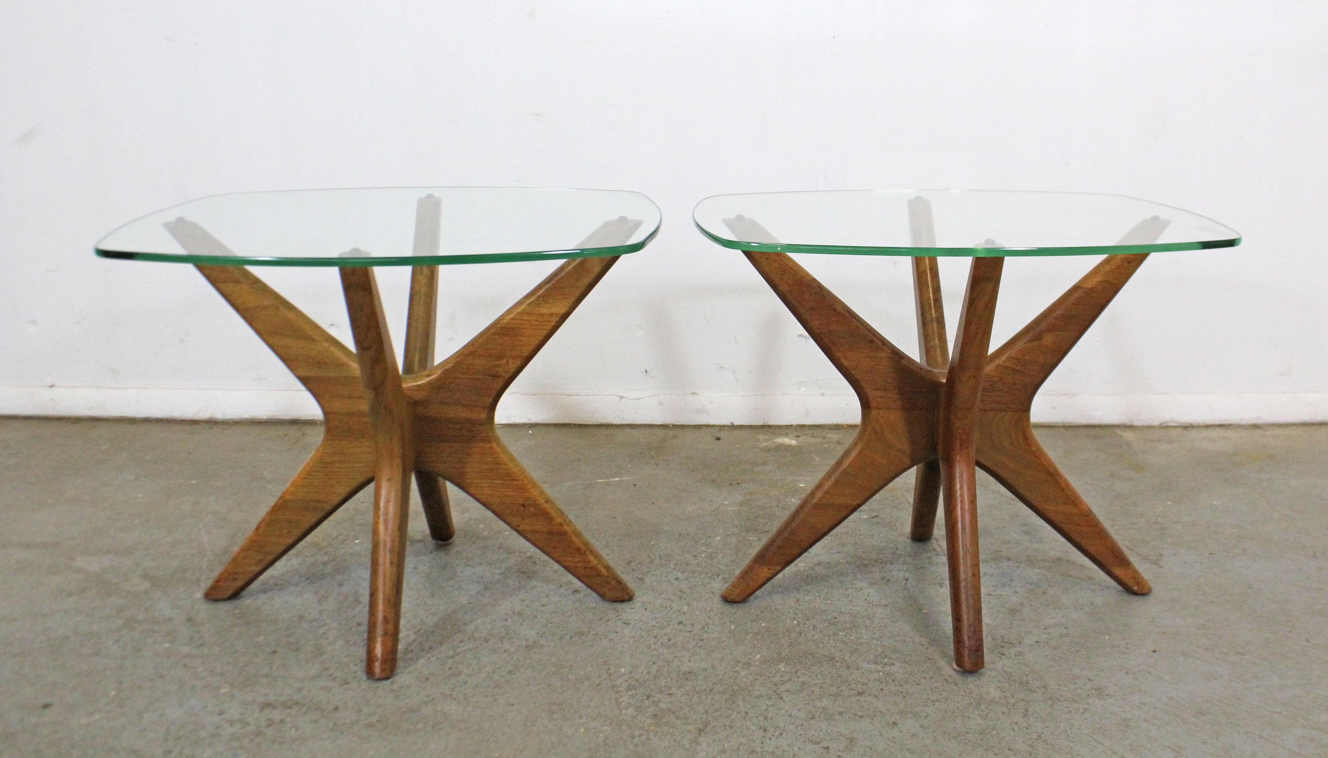 Offered is an authentic pair of vintage Adrian Pearsall 'Jacks' end tables with sculpted wooden bases and thick glass tops. In good condition for their age showing some age wear including surface scratches on wood and glass, small chip on one glass