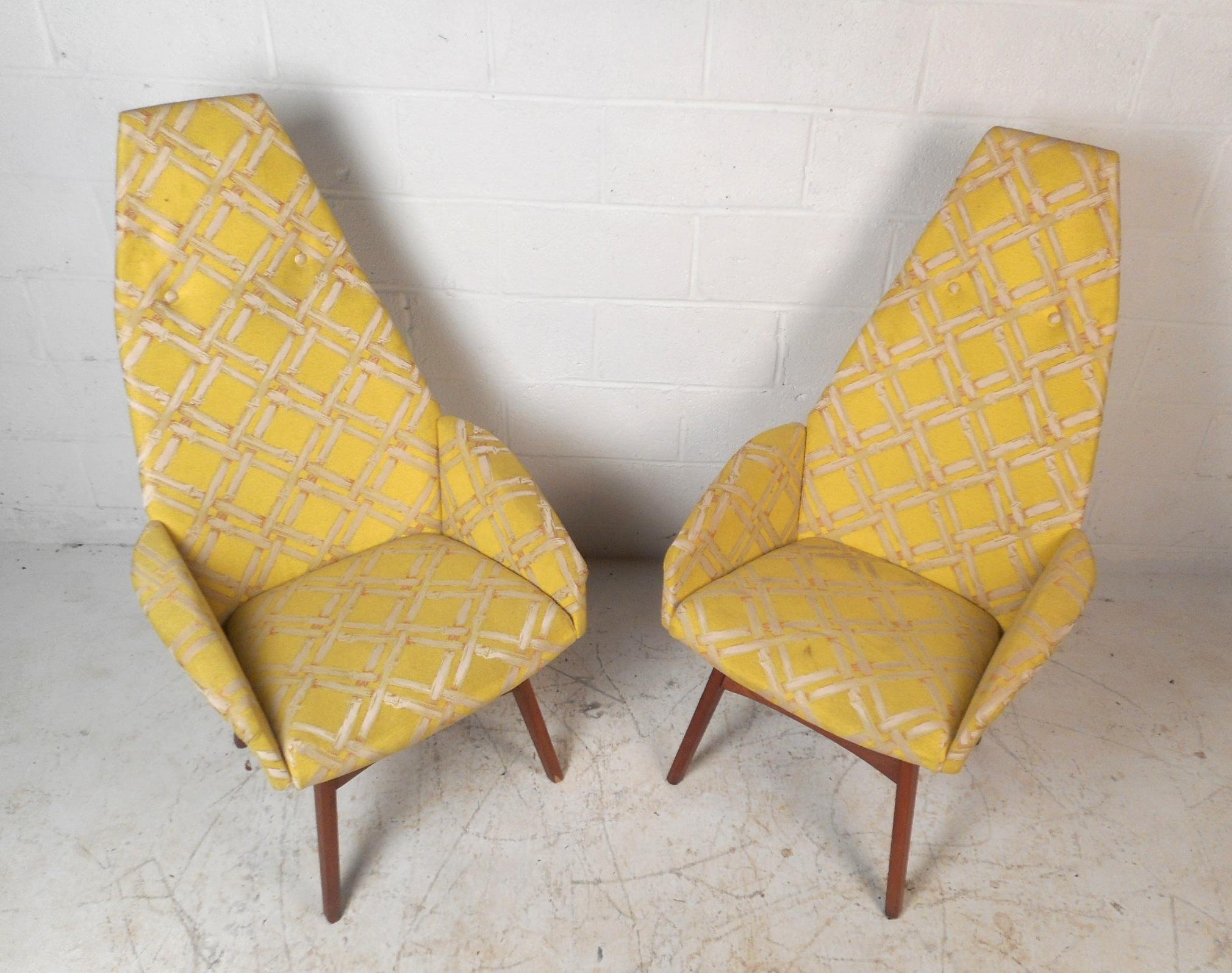 This beautiful pair of vintage modern lounge chairs feature winged arm rests, splayed legs, and a high back rest. A decorative yellow upholstery and sturdy walnut base add to the allure. This comfortable and sleek pair of his/hers Adrian Pearsall