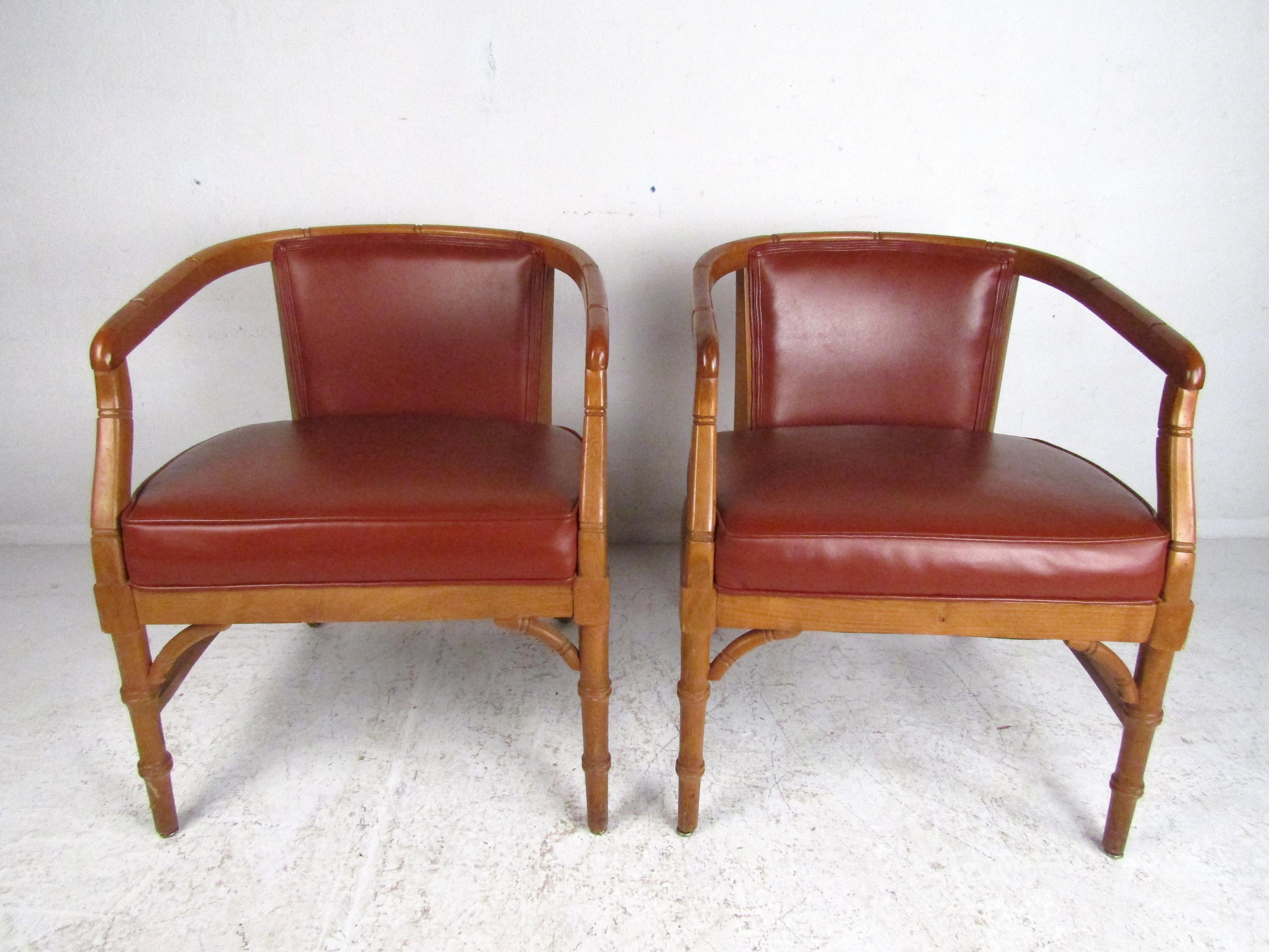 Stunning pair of Mid-Century Modern armchairs. Seats and backs are covered in a vintage faux-leather upholstery. Stylishly contoured frame. Please confirm item location with dealer (NJ or NY).