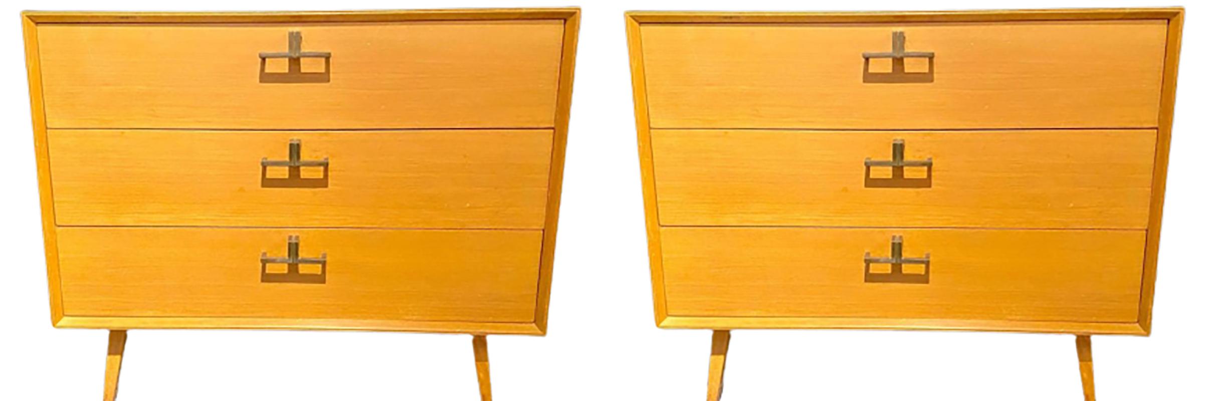 Pair of Mid-Century Modern bachelor chests, commodes, nightstands or dressers. A finely constructed pair of three-drawer commodes, all wood, with brass mounts having a sleek and simply flair. The pair with sprayed legs supporting a large case