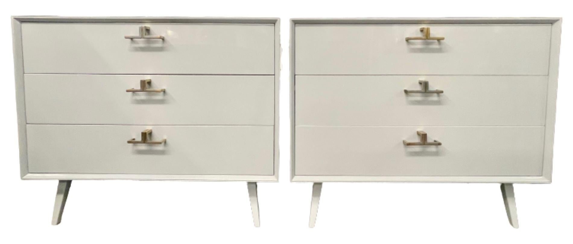 Pair of Mid-Century Modern bachelor chests, commodes, nightstands or dressers in a high gloss grey lacquer. A finely constructed pair of three-drawer commodes, all wood, with brass mounts having a sleek and simply flair. The pair with sprayed legs