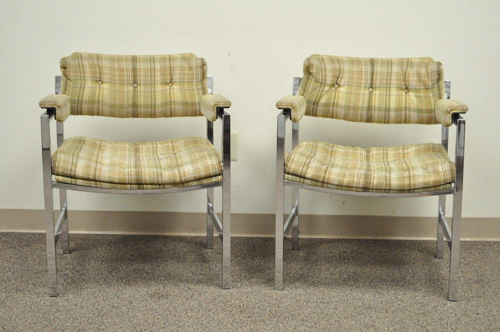 Unique pair of vintage Mid-Century Modern chrome arm chairs. Maker is unknown but the style and quality is very similar to Milo Baughman. Item details square chrome frames, floating form armrests with raised walnut underside, and clean modernist