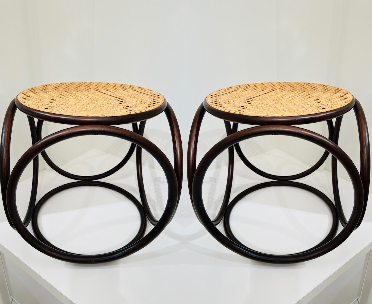 Pair of 1960s minimalist side tables in bentwood and cane. Comprised of six circular bentwood components creating a striking geometric design with the illusion of movement. Fitted with handwoven cane top and newly refinished in dark walnut. These