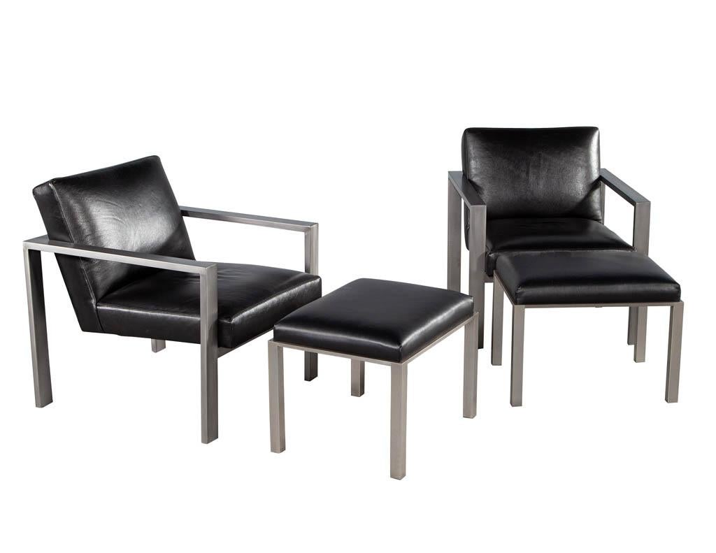 Pair of Mid-Century Modern black leather metal lounge chairs. America circa 1970’s. Featuring dark gunmetal stainless-steel frames with modern styling. Upholstered in premium Italian black leather with thick foam padding. Includes accenting ottoman