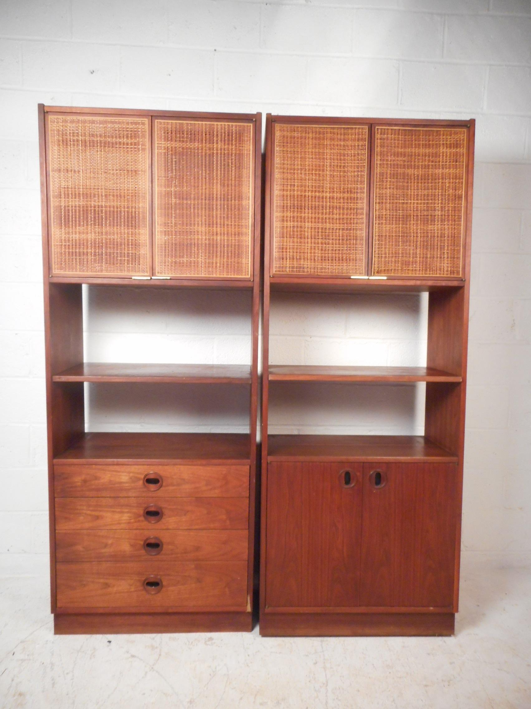 This stunning pair of vintage modern free standing wall units feature plenty of room for storage within its numerous drawers and compartments. A versatile design that makes the perfect display case or storage piece. Wonderful cane front cabinets