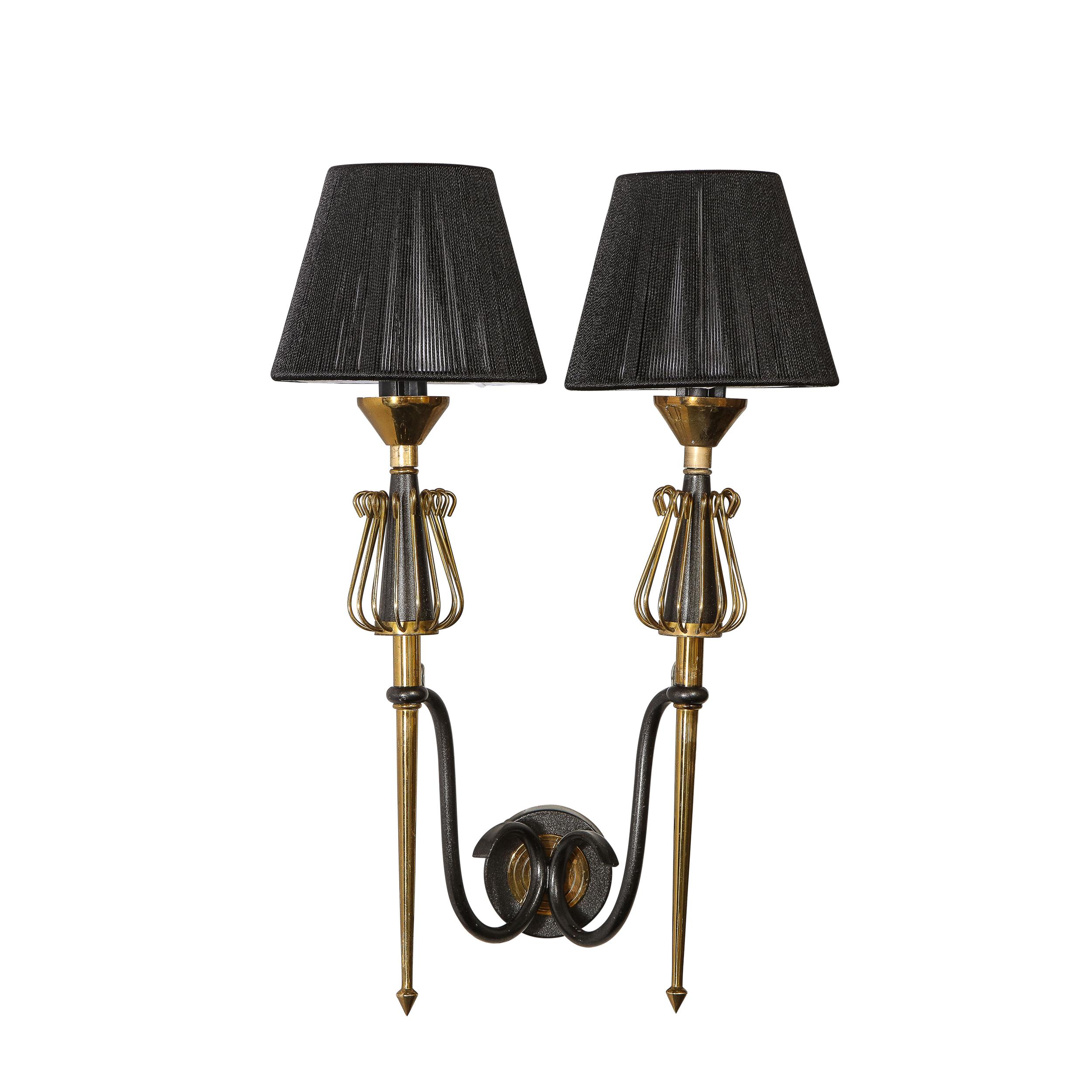 Questa elegante coppia di appliques del Mid-Century Modern è stata realizzata in Francia intorno al 1950. Presentano una piastra posteriore circolare con supporti curvilinei in smalto nero che emanano verso l'esterno e che sostengono i corpi