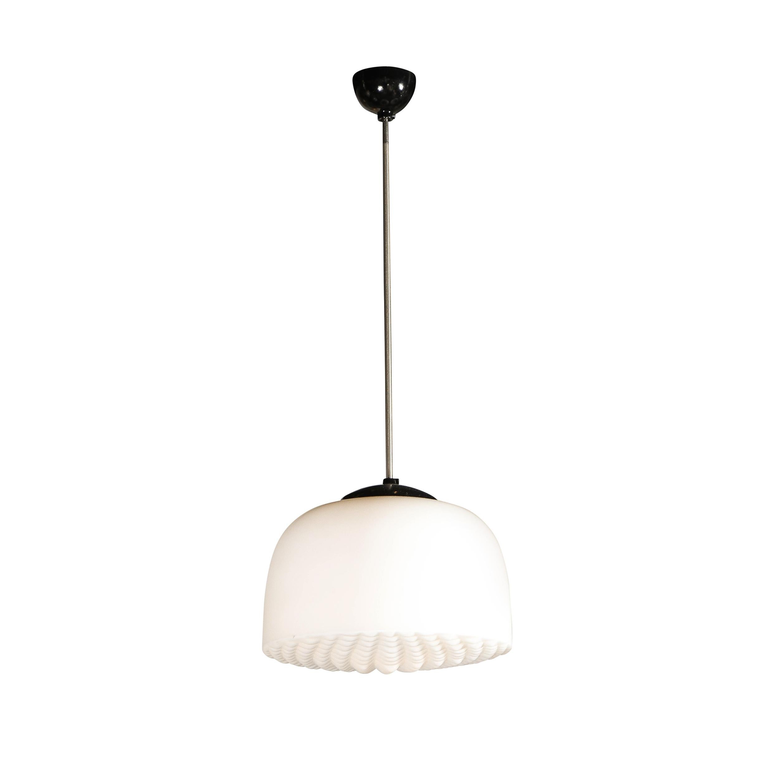 This refined pair of Mid-Century Modern pendants were realized in the Czech Republic circa 1950. The feature graphic domed shades with a rectilinear 