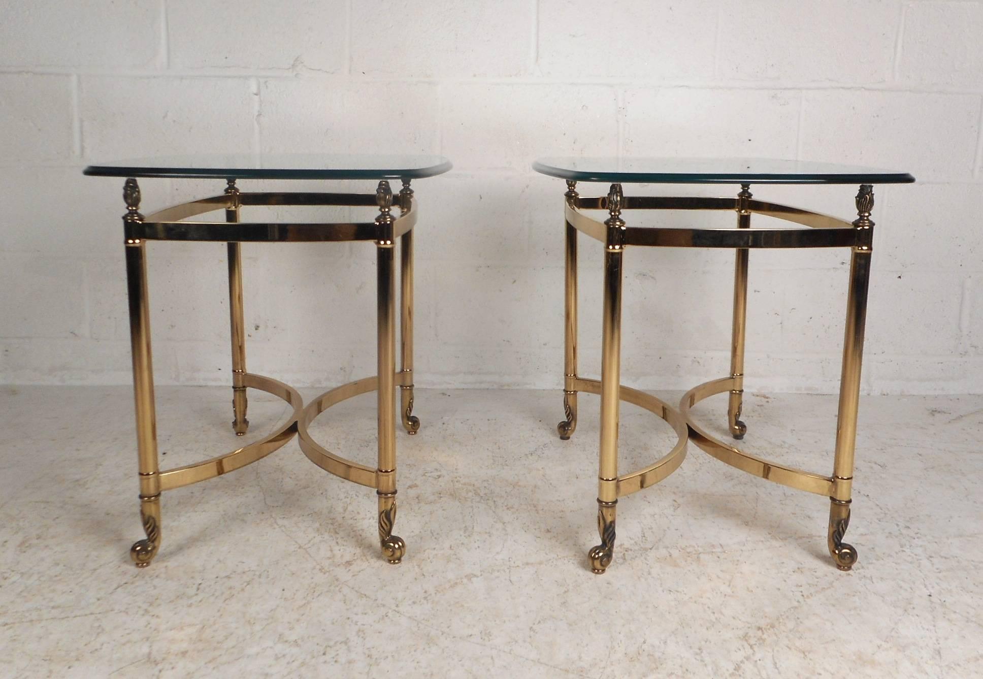 Unique pair of vintage modern side tables with heavy brass bases and thick bevelled glass tops. Sleek design with an ellipse shape in the centre of the base and sculpted feet. These wonderful midcentury tables have remarkable etched detail on the