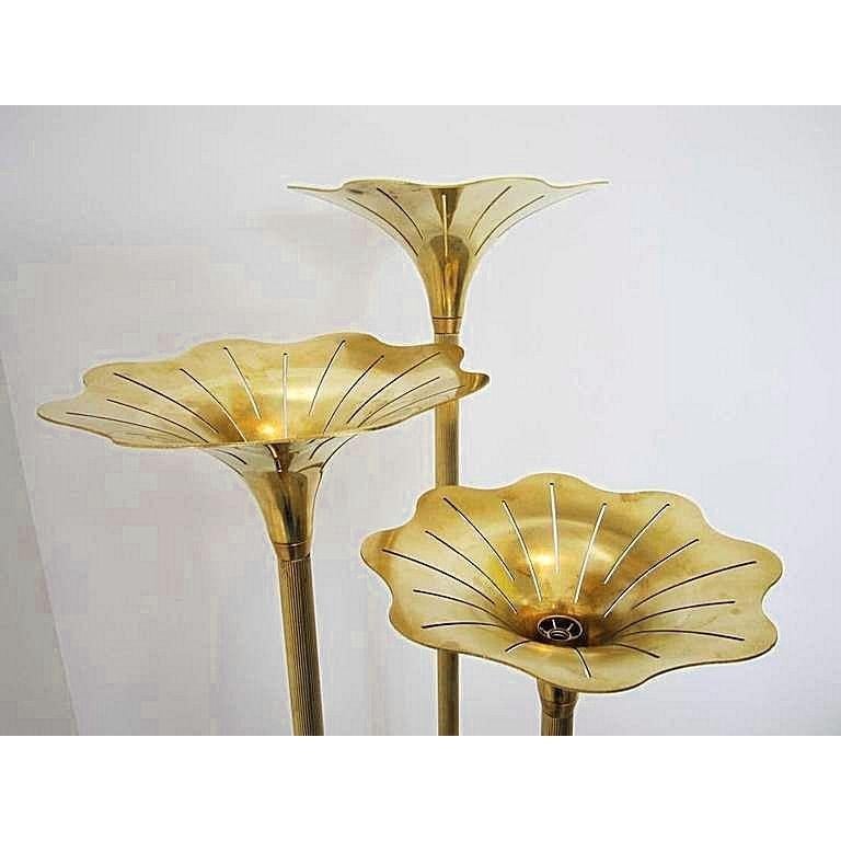 Striking pair of Italian Mid-Century Modern floor lamps, in brass, attributed to Gabriella Crespi. Each lamp has three brass flowers, holding one light each in each. 
Tri-pod fluted legs. 
Beautiful patina. 
Lamps have been rewired.