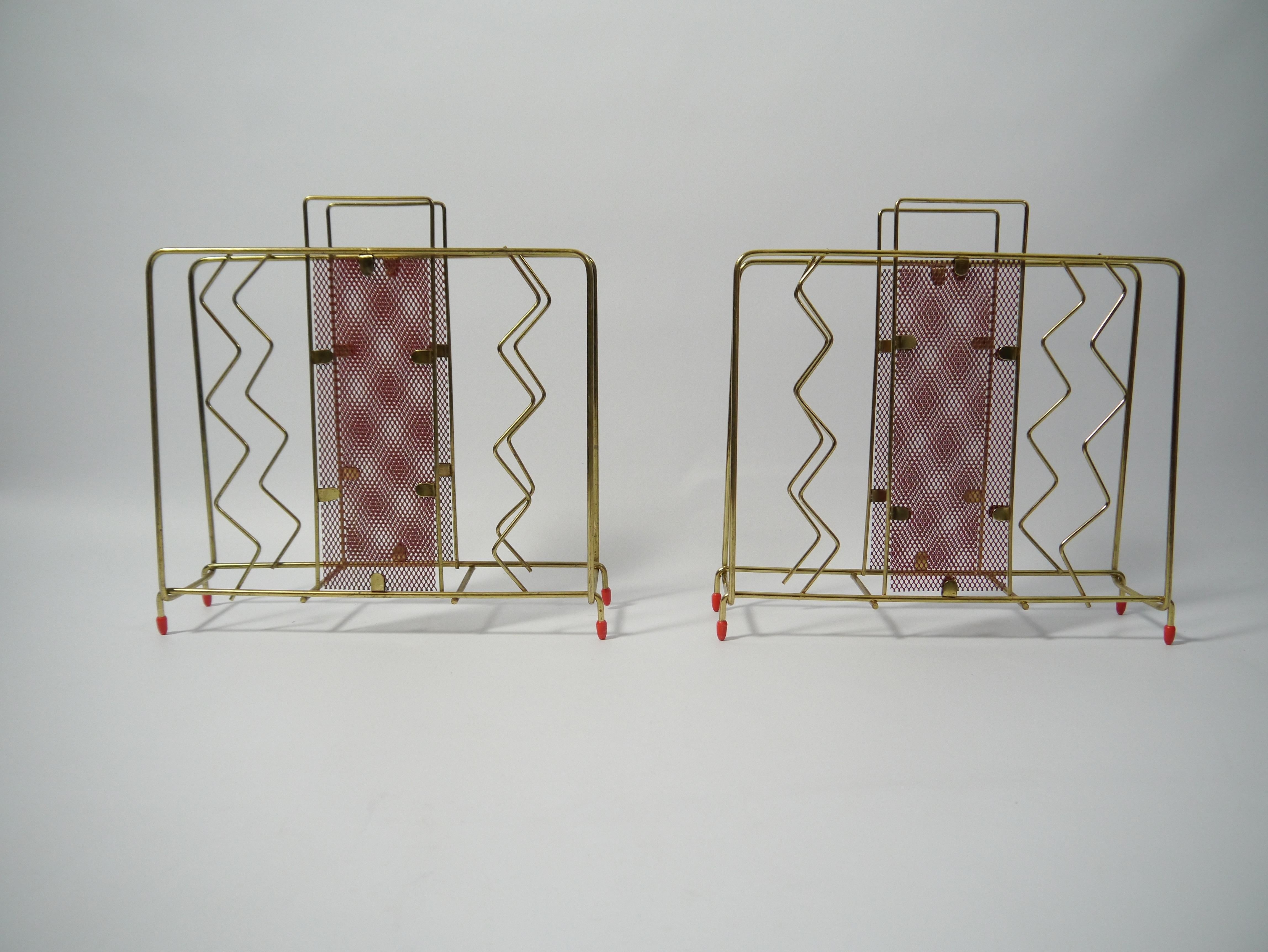 Ein Paar Zeitschriftenständer aus vermessingtem Metall und rot lackierten, gelochten Metallplatten. Nach dem Vorbild von Mathieu Matégot.