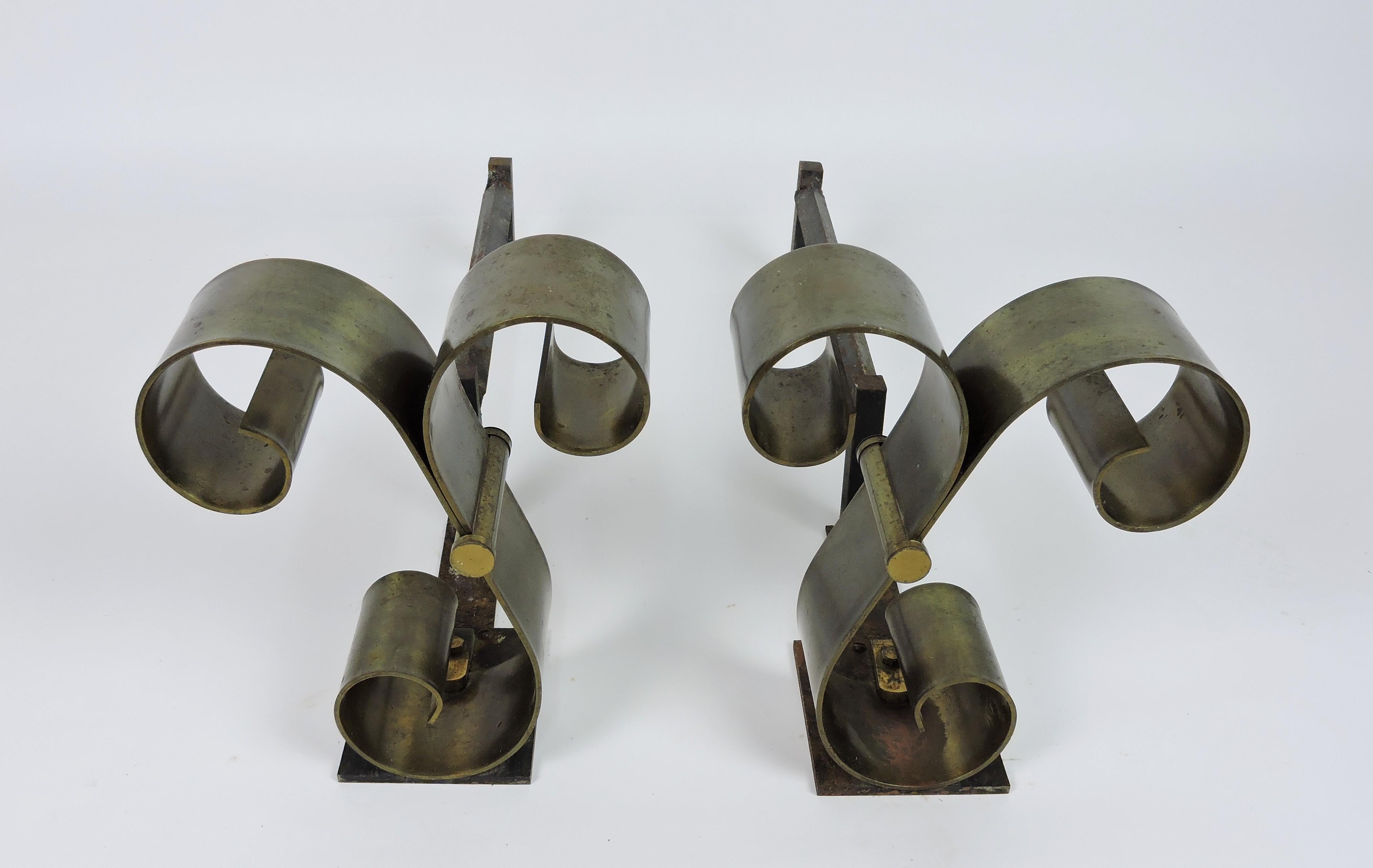 Beautiful pair of Mid Century scroll form andirons in the style of Raymond Subes. The scrolls are solid brass and the legs are forged iron. These have the original finish.