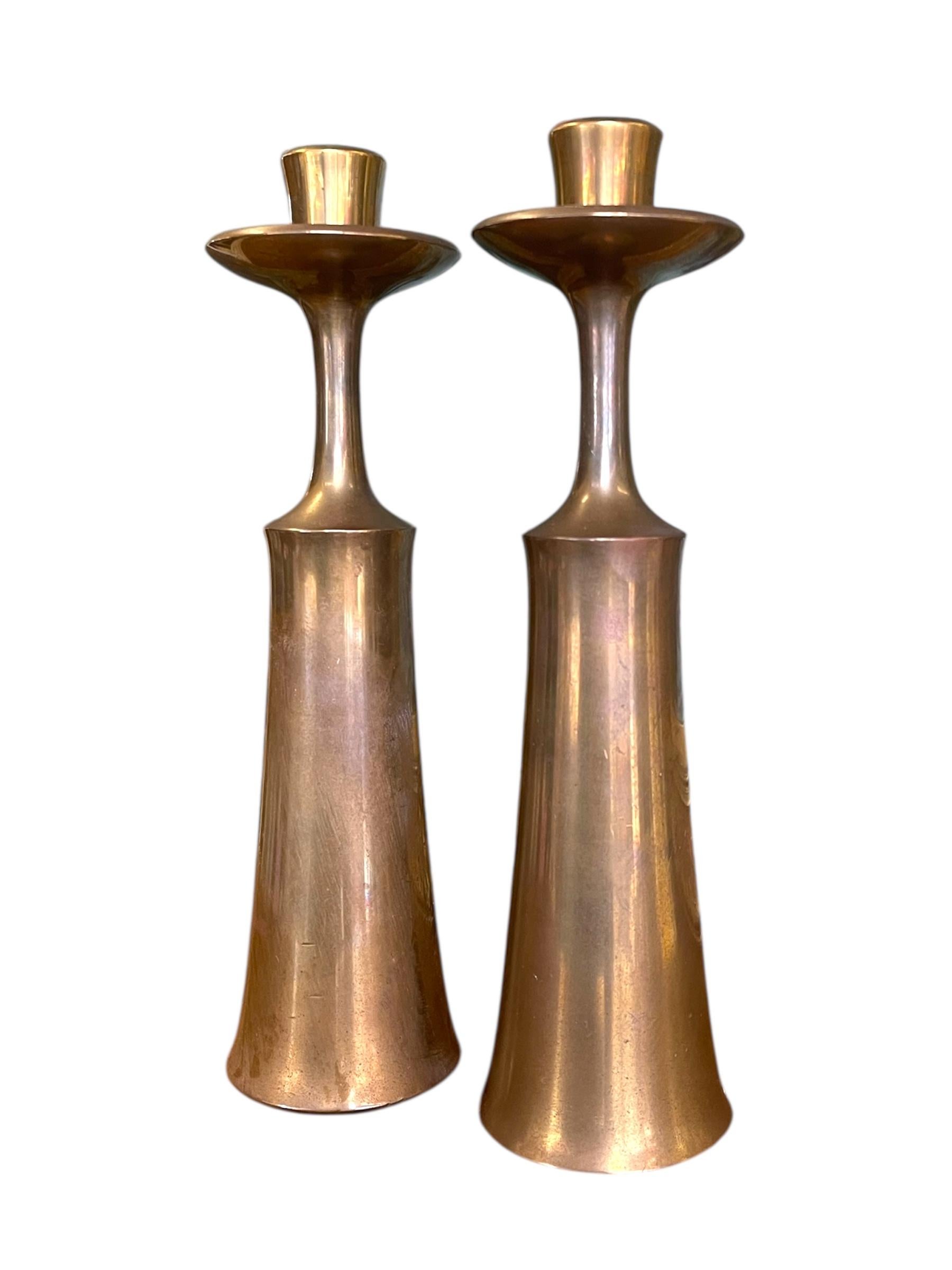 Una raffinata coppia di portacandele Mid-Century Modern disegnati da Jens H. Quistgaard per Dansk Designs, Danimarca. Questi pezzi scultorei mostrano l'approccio caratteristico di Quistgaard al modernismo scandinavo, elegante, minimale e