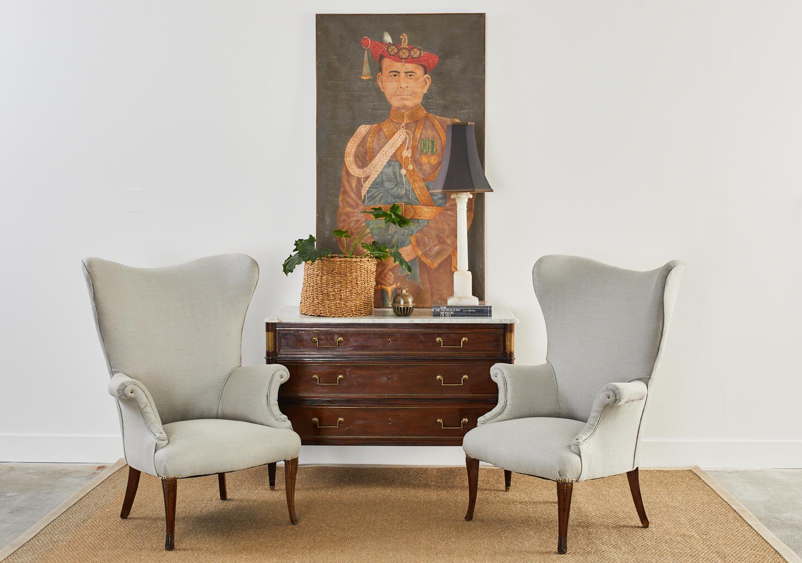 Extraordinary pair of Mid-Century Modern wingback armchairs featuring hardwood frames with newly upholstered seating surfaces. The stylish large wings are reminiscent of Edward Wormley's designs for Dunbar with their thin sleek shape. The chairs