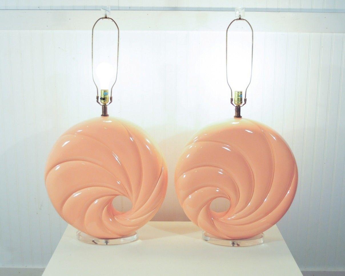 Pair of large vintage or contemporary swirl form ceramic lamps with Lucite bases and finials. Items feature great decorator form, twisted ceramic bodies with a donut hole through the center. The color is a soft pink or light coral color. The exact