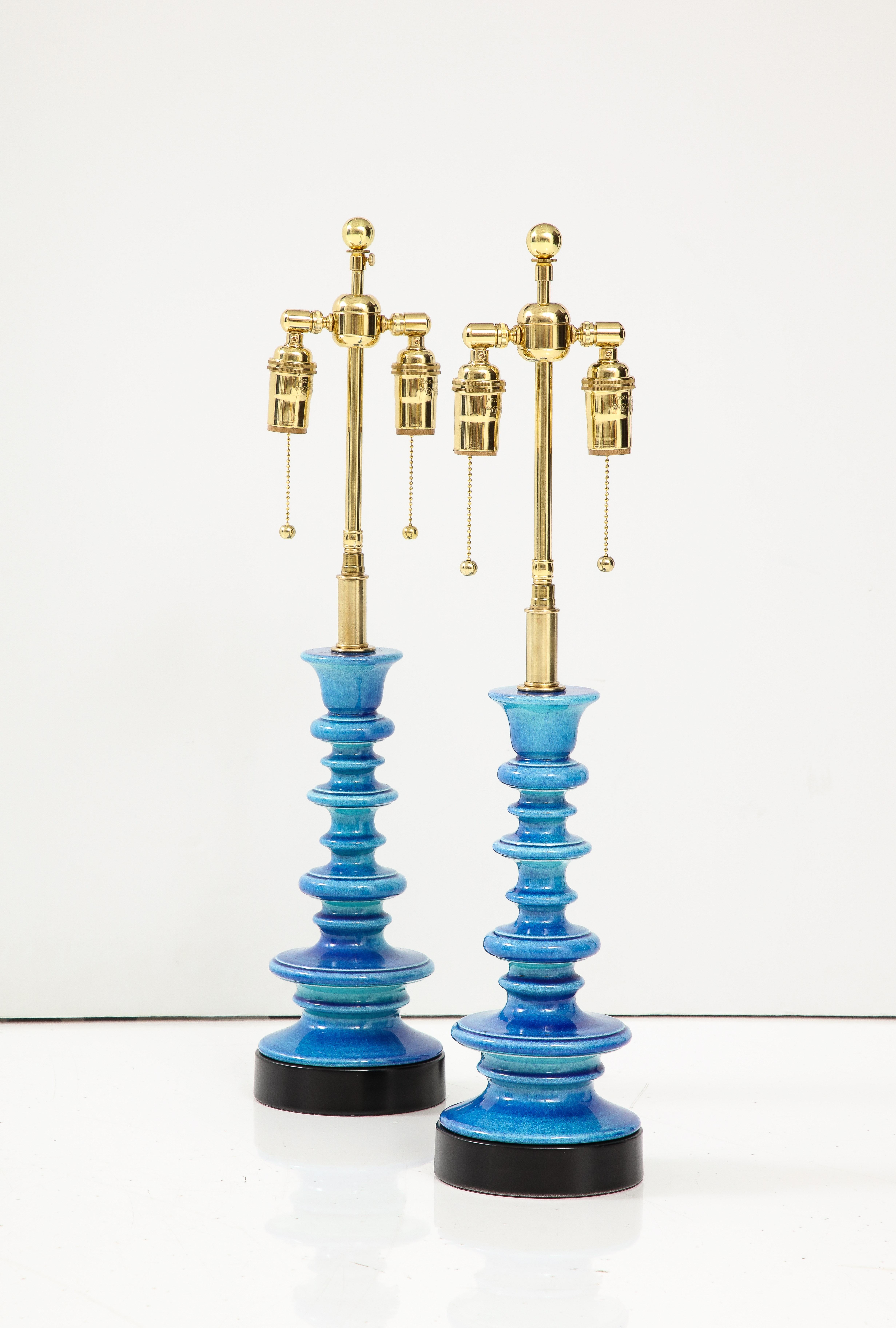Ein Paar pagodenförmige Keramiklampen in einer atemberaubenden ceruleanblauen Glasur.
Die Lampen wurden neu verkabelt mit einstellbaren polierten Messing-Doppelclustern, die Glühbirnen in Standardgröße und Seidenrayonschnüre aufnehmen.
Jede Fassung