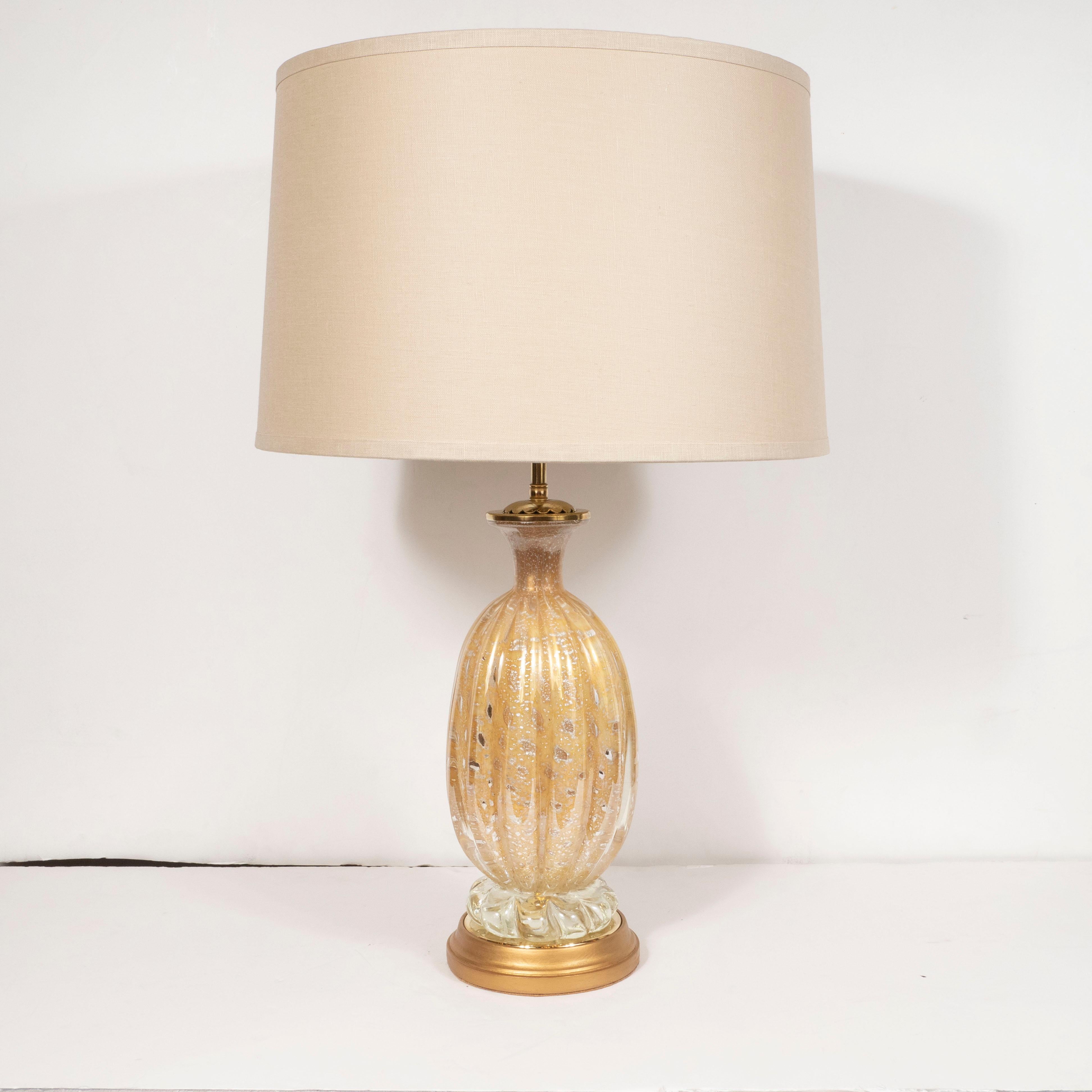This stunning pair of Mid-Century Modern table lamps were realized by the fabled Italian atelier of Barovier e Toso in Italy, circa 1950. Realized in beautiful Murano glass infused with 24-karat yellow and white gold flecks as well murines