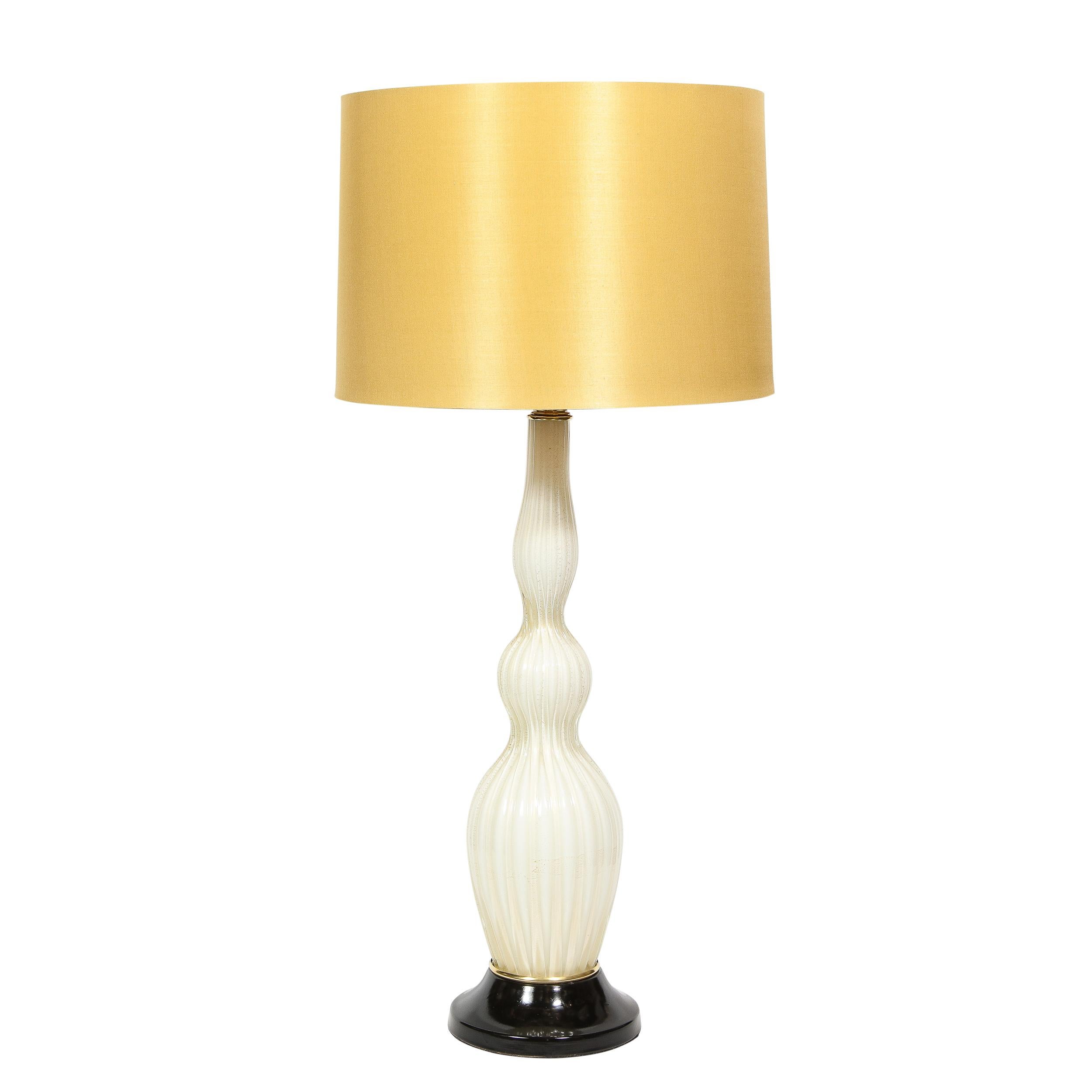 This elegant pair of Mid-Century Modern sculptural table lamps were realized in Murano, Italy- the island off the coast of Venice renowned for centuries for its superlative glass production, circa 1950. They feature undulating channeled bodies in a