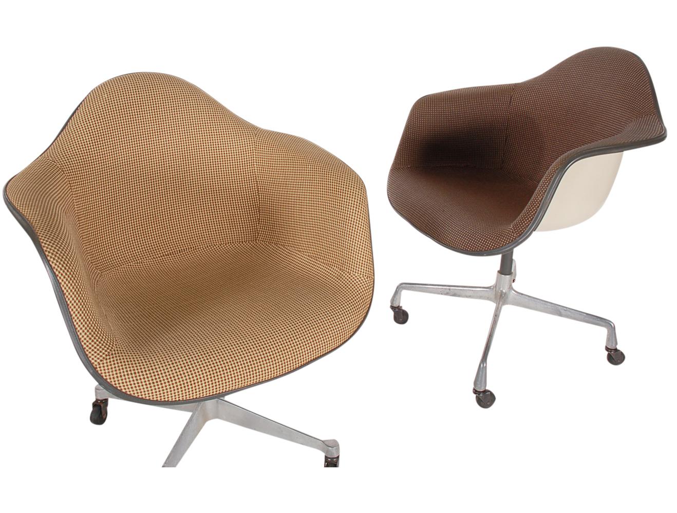 A super clean vintage set of original armchairs designed by Charles Eames for Herman Miller. They feature molded fiberglass buckets seats with complimenting upholstery, and caster bases. Manufacturer labels to both.