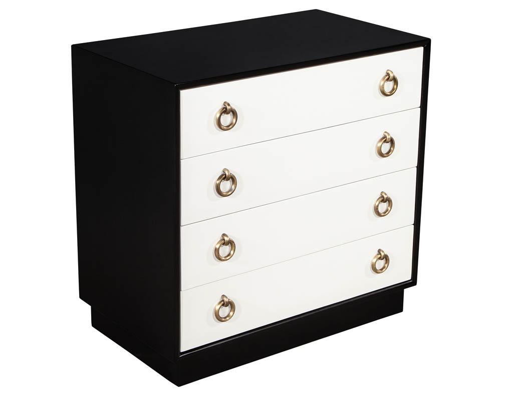 Pair of Mid-Century Modern chests of drawers black and white finish. Featuring mahogany woods with four drawers, lined in soft black fabric. Refinished in a two tone look with original solid brass ring hardware.

Price includes complimentary curb