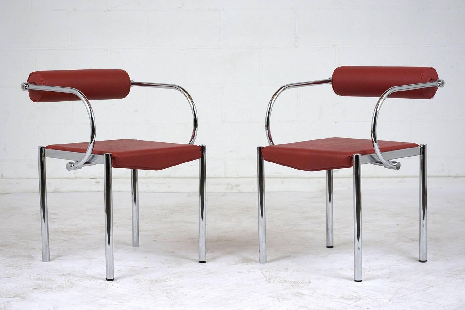 This pair of 1970s Mid-Century Modern Space Age style armchairs feature unique steel frames with a chrome finish. The curved arms attach to a floating backrest with a round cushion. The seat and backrest are upholstered in a striking red color