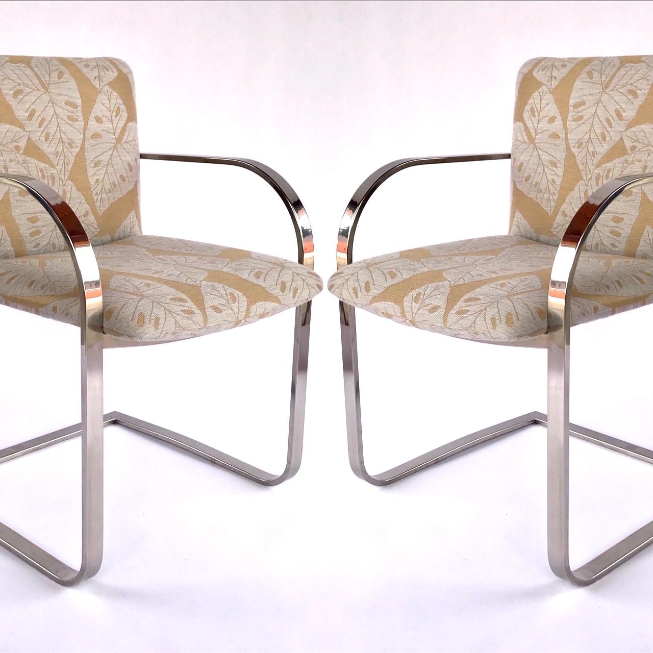 Mid-Century Modern desk chairs or side chairs with cantilevered steel frames in chrome. Chairs have streamlined profile with curved armrests and floating seat design. Newly upholstered in bold handwoven fabric with tropical leaf print in