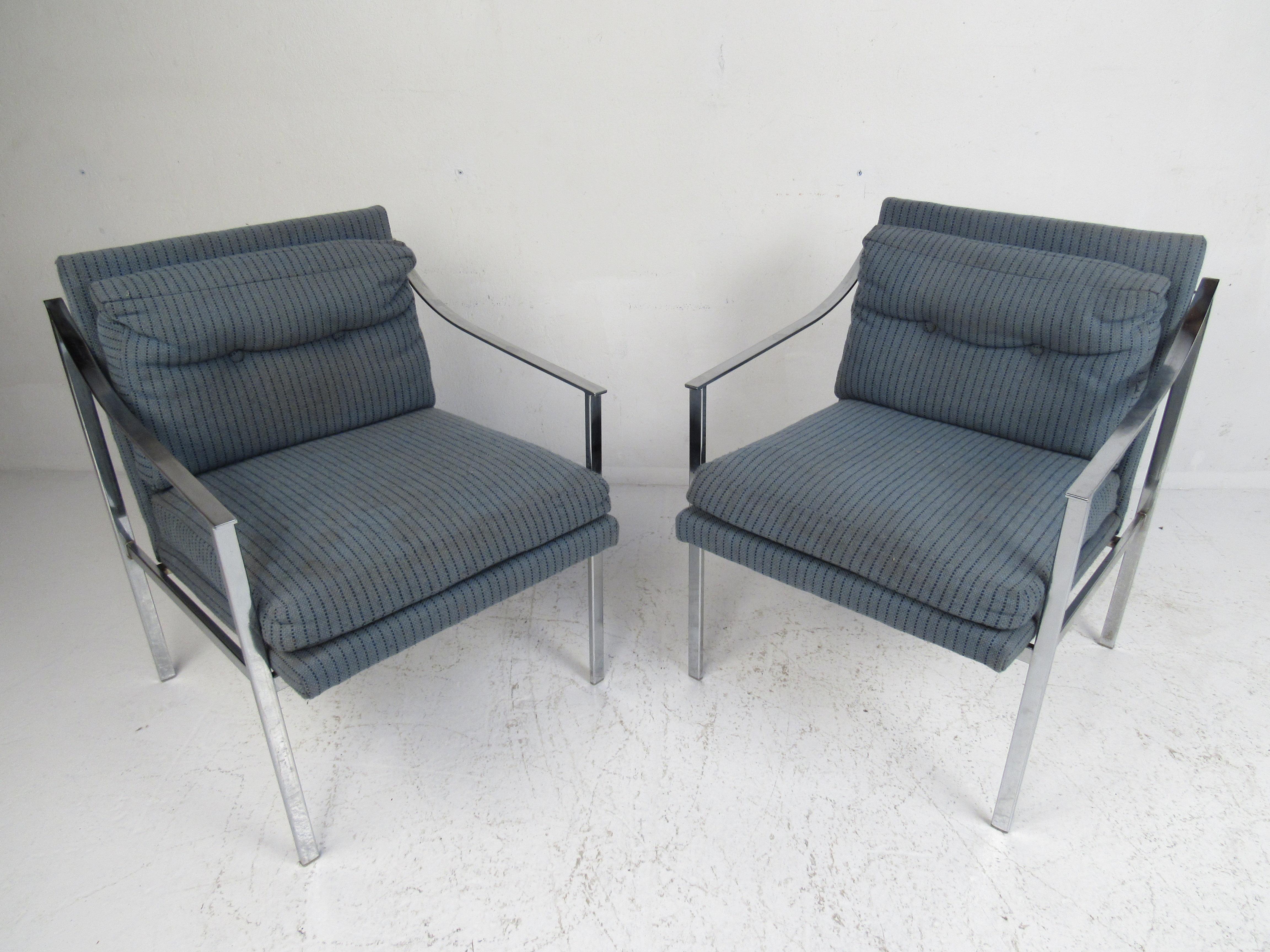 This stunning vintage modern pair of lounge chairs feature a heavy flat bar chrome frame and thick padded seats. The unique sloped armrests and tufted backrest add to the midcentury appeal. This exquisite pair of Milo Baughman style lounge chairs