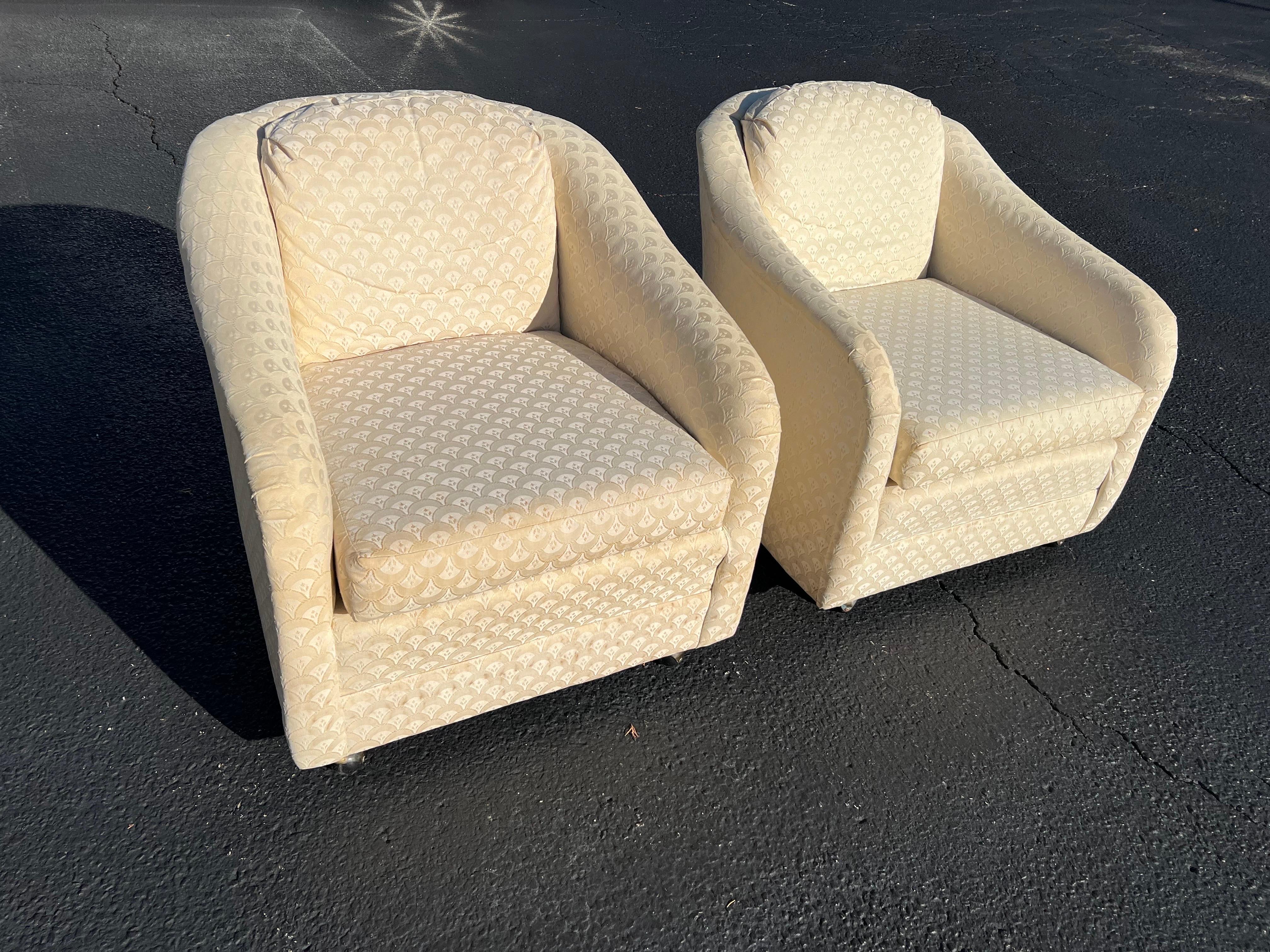 Pair of Mid-Century Modern club chairs on castors. Nice neutral shaped cream chairs in a chevron design upholstery. Solid well built cube chairs. Probably could use a recover. Some slight stains. 
Measure: Seat depth is 21