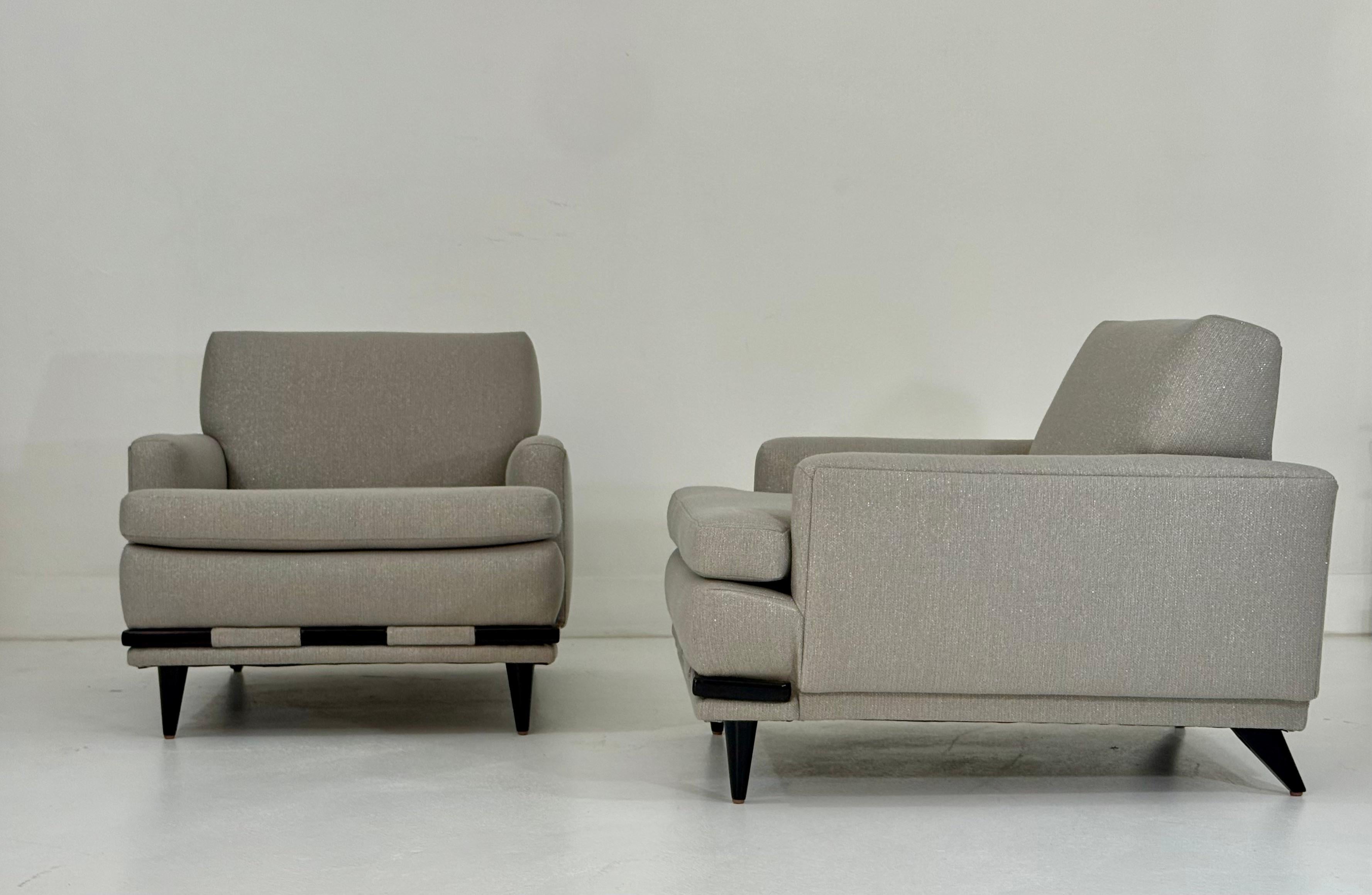 Questa elegante coppia di sedie da club moderne di metà secolo offre una miscela perfetta di stile senza tempo e comfort invitante. Sapientemente restaurata, ogni sedia è stata rivestita di nuovo con il lussuoso tessuto Coraggio, un tessuto