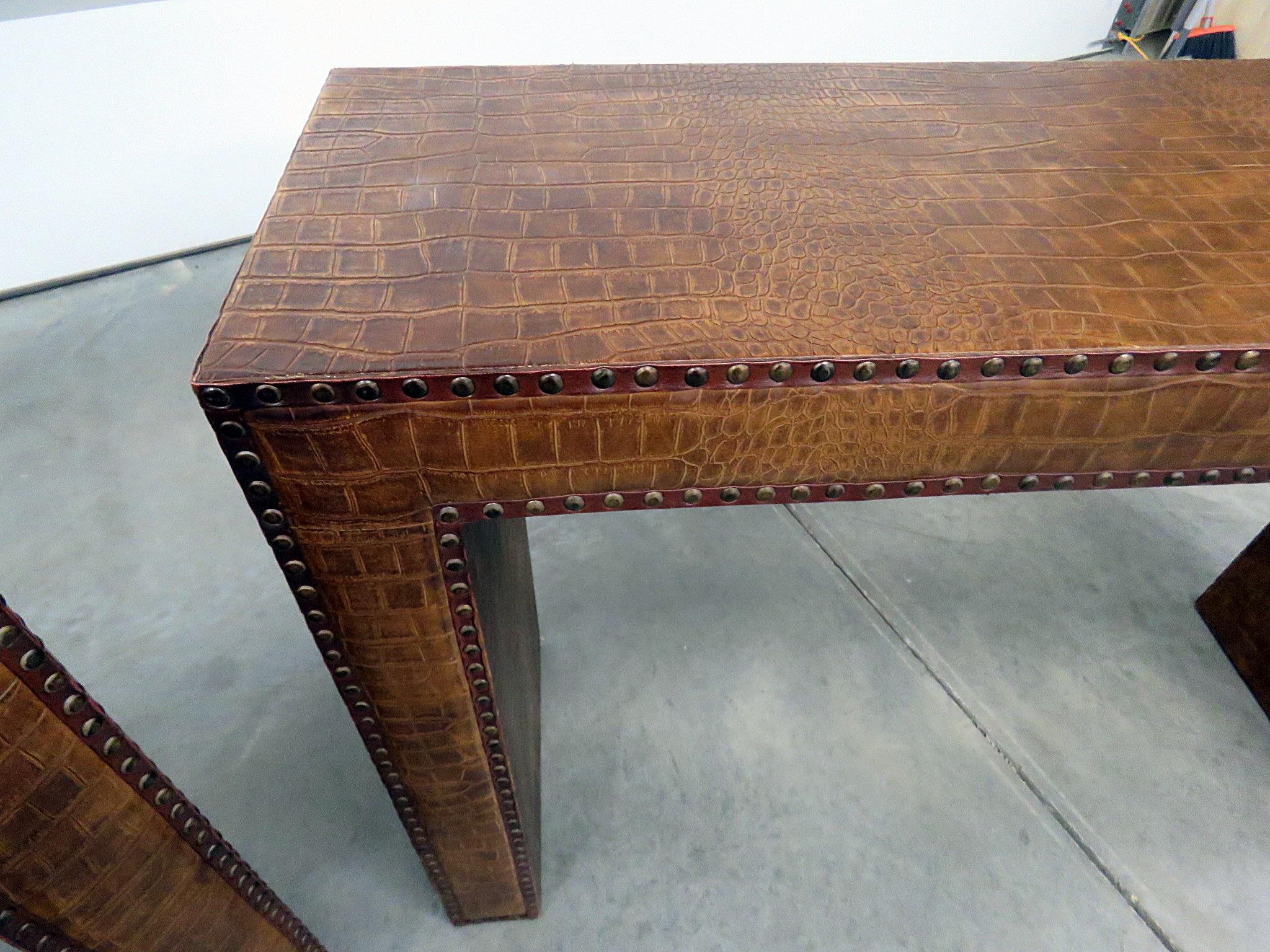 Pair of Mid-Century Modern console tables wrapped in faux hide with nailhead trim.