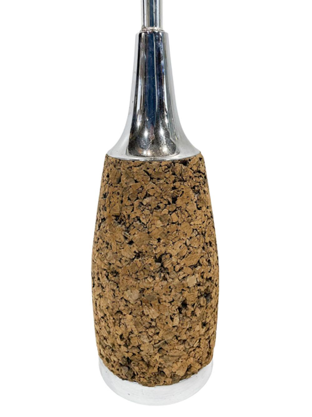 Large pair of MCM cork table lamps of bottle-form, the cork body is set on a circular chrome foot and topped with a bell-form cone neck, also in chrome. Large harps with ball finials are included.