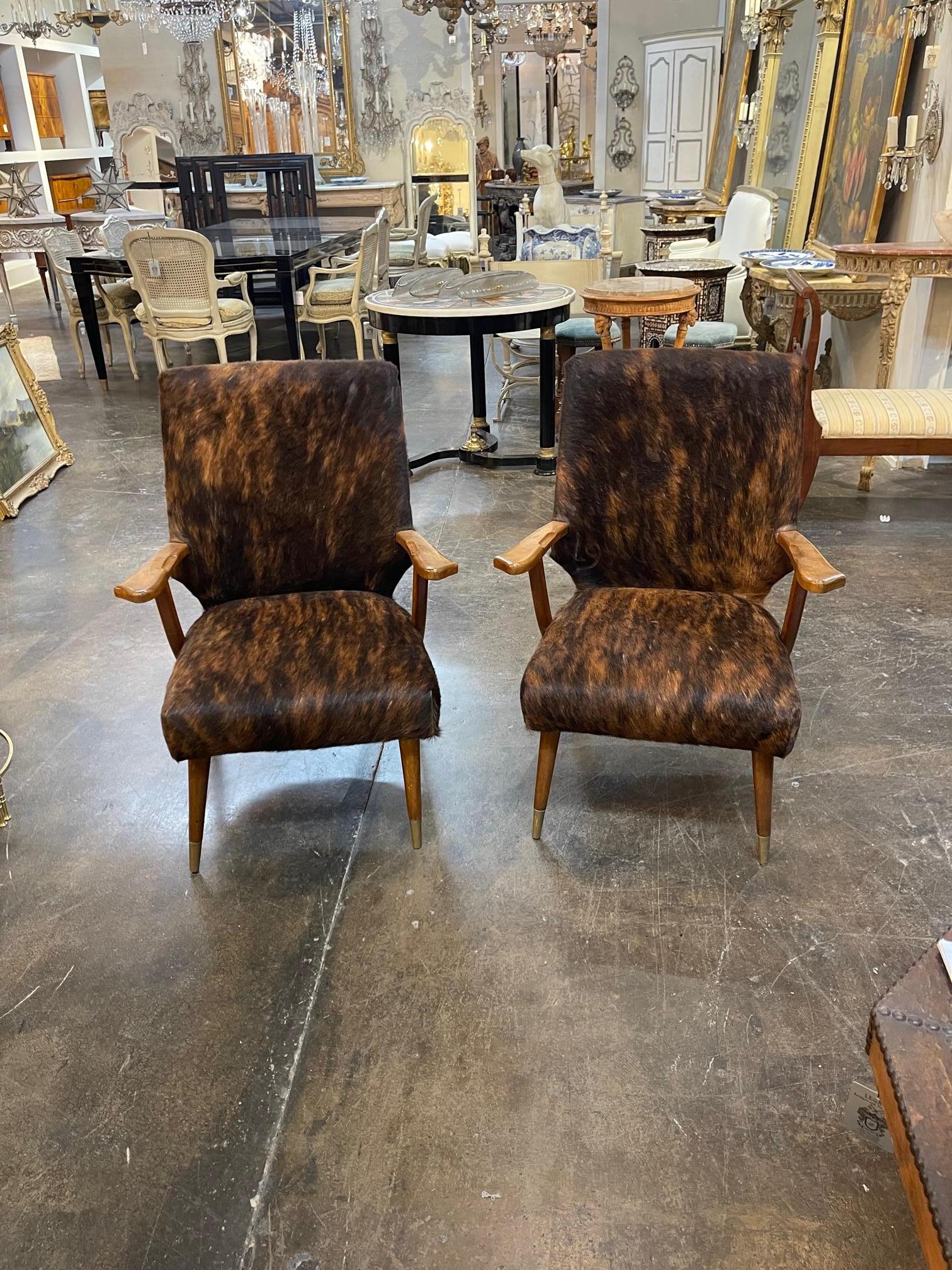 Lovely pair of Mid-Century Modern armchairs upholstered in cowhide in the style of designer Gio Ponti. Beautiful clean lines. Very stylish!