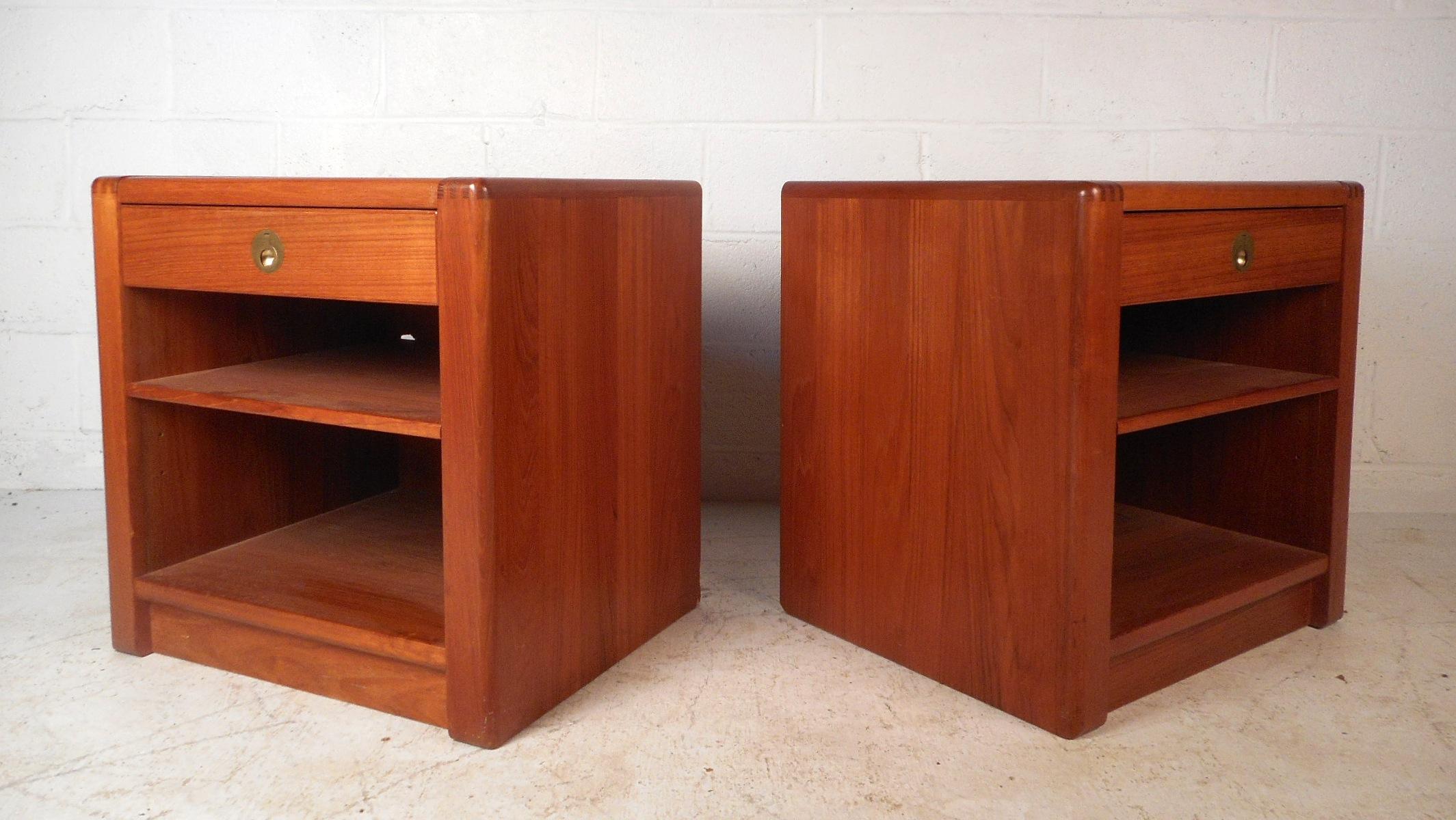 This beautiful pair of Danish teak nightstands have a sleek design and plenty of storage space. The drawers feature unique recessed brass pulls. These nightstands boast rounded off dovetail joints, adding style to the sturdy construction. Please