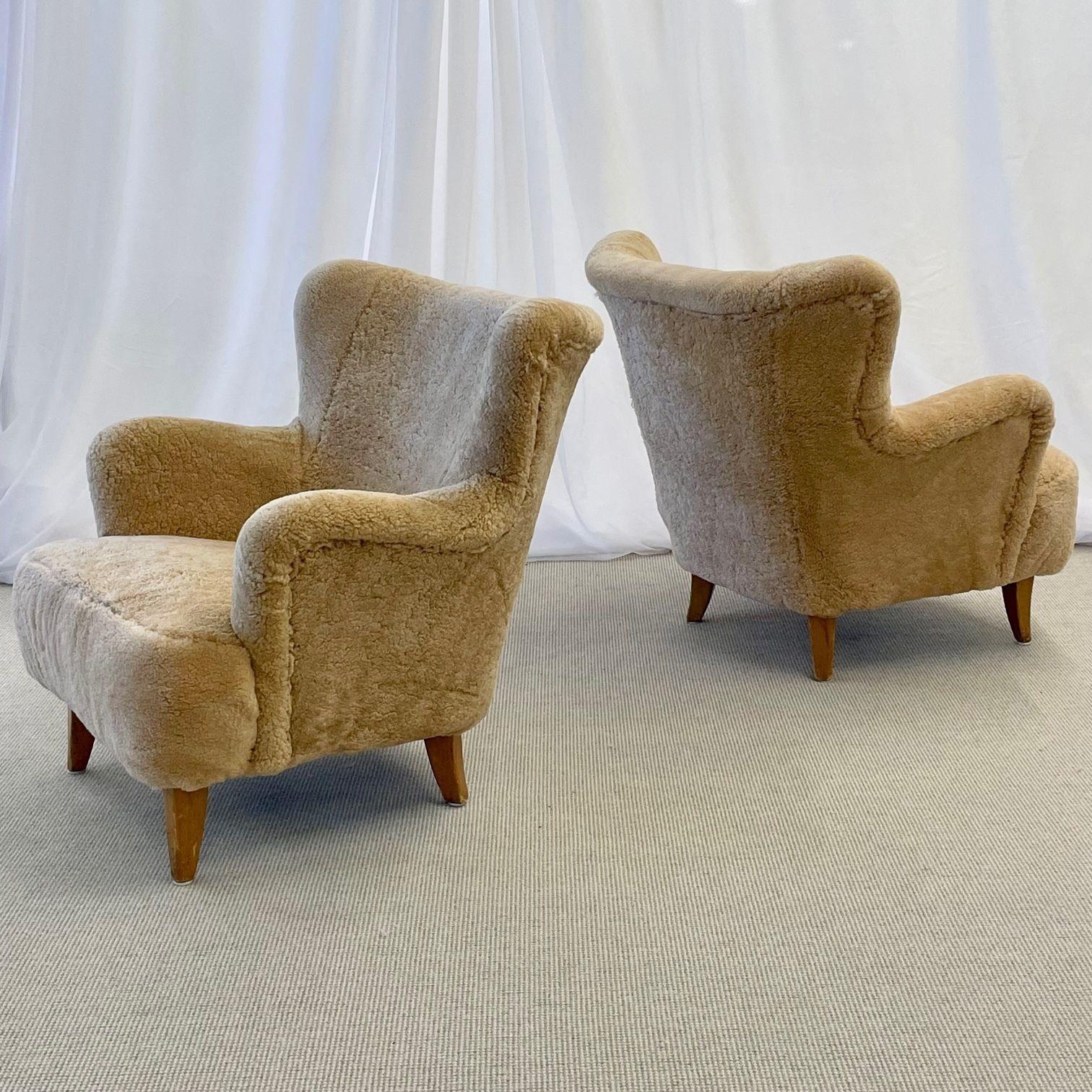 Pair of Mid-Century Modern Danish cabinet maker lounge, club or wingback chairs.
 
Newly upholstered honey sheepskin, lacquered wood.
Denmark, 1950s
 
Other Scandinavian designers of the period include Finn Juhl, Kaare Klint, Borge Mogensen,