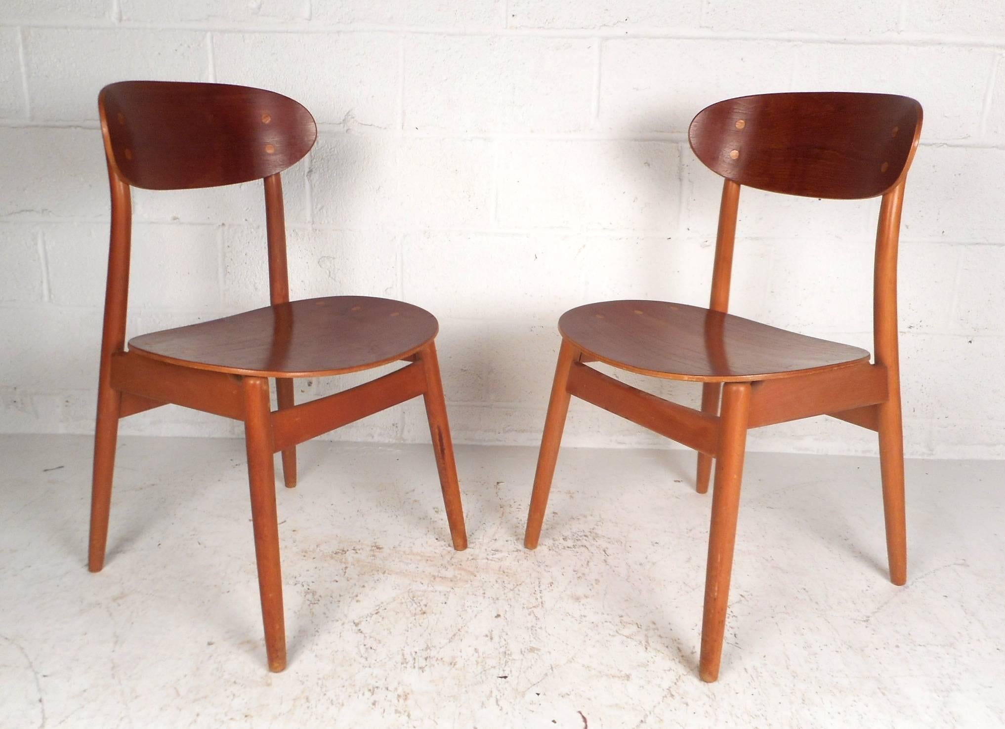 Wonderful pair of vintage modern chairs with curved wing style back rests and contoured seats. Sturdy Danish design with tapered legs and dovetail construction. This unique pair of midcentury side chairs offer plenty of comfort without sacrificing