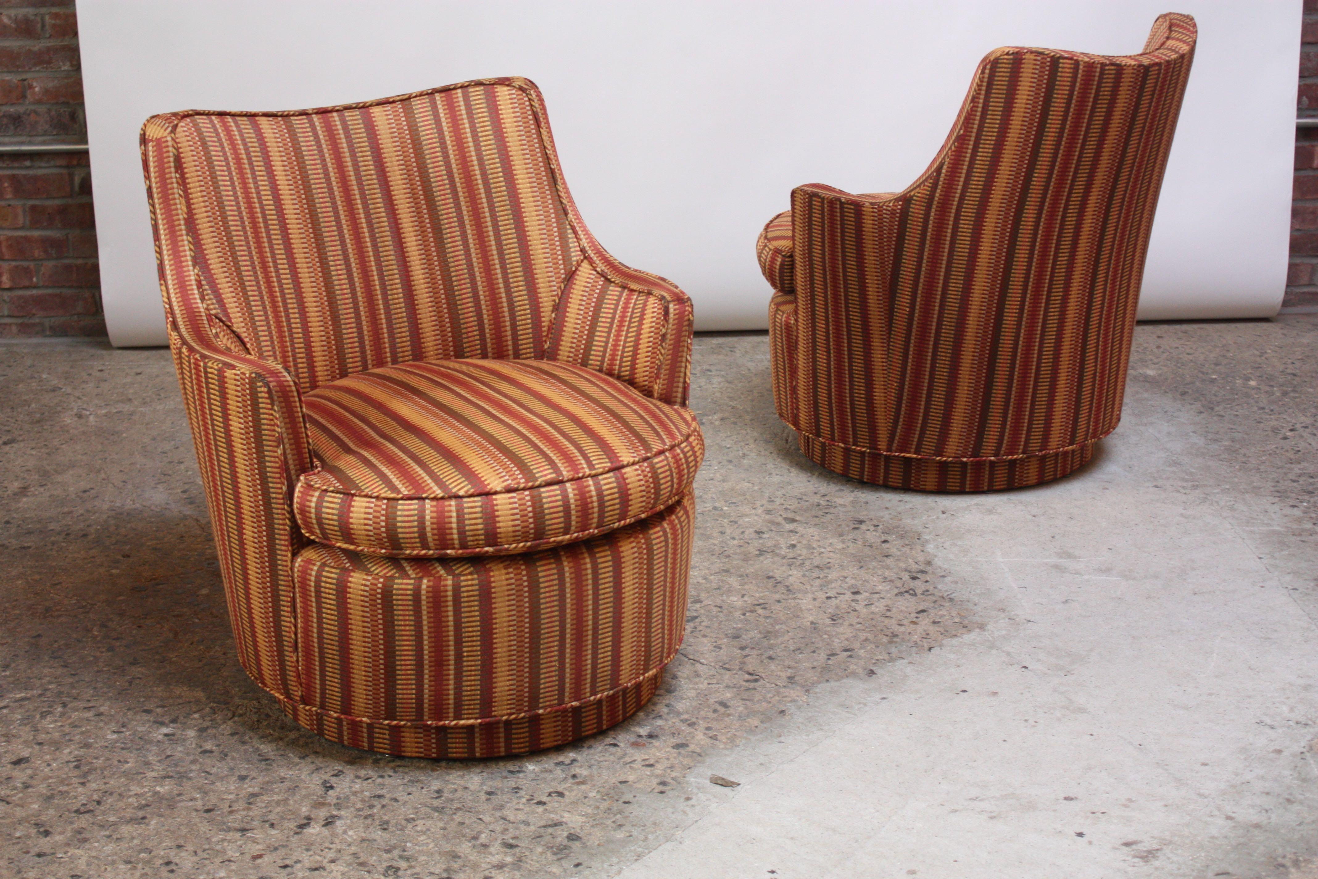 Small scale Mid-Century Modern armchairs with swivel function reminiscent of Edward Wormley's design for Dunbar but unmarked. The chairs and swivel bases were reupholstered (likely in the 1970s or 1980s), and there is slight wear commensurate with