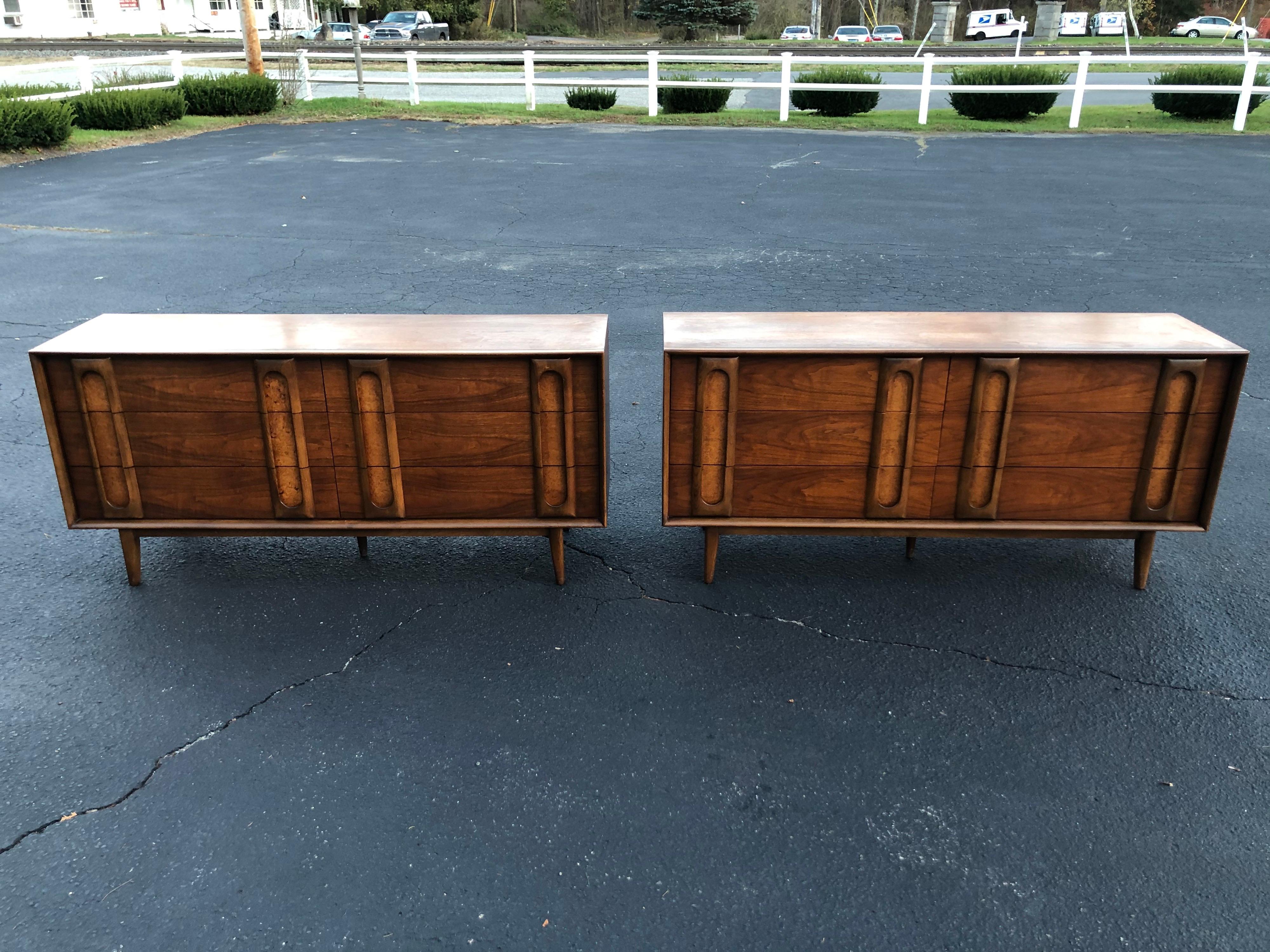 Pair of Mid-Century Modern dressers by Lane. Sculptural walnut dressers with a soft burl wood panel at the handles. Classic and timeless design. Use as a dresser or as a server /credenza. 6 drawers per dresser. We can break up the set if you want to