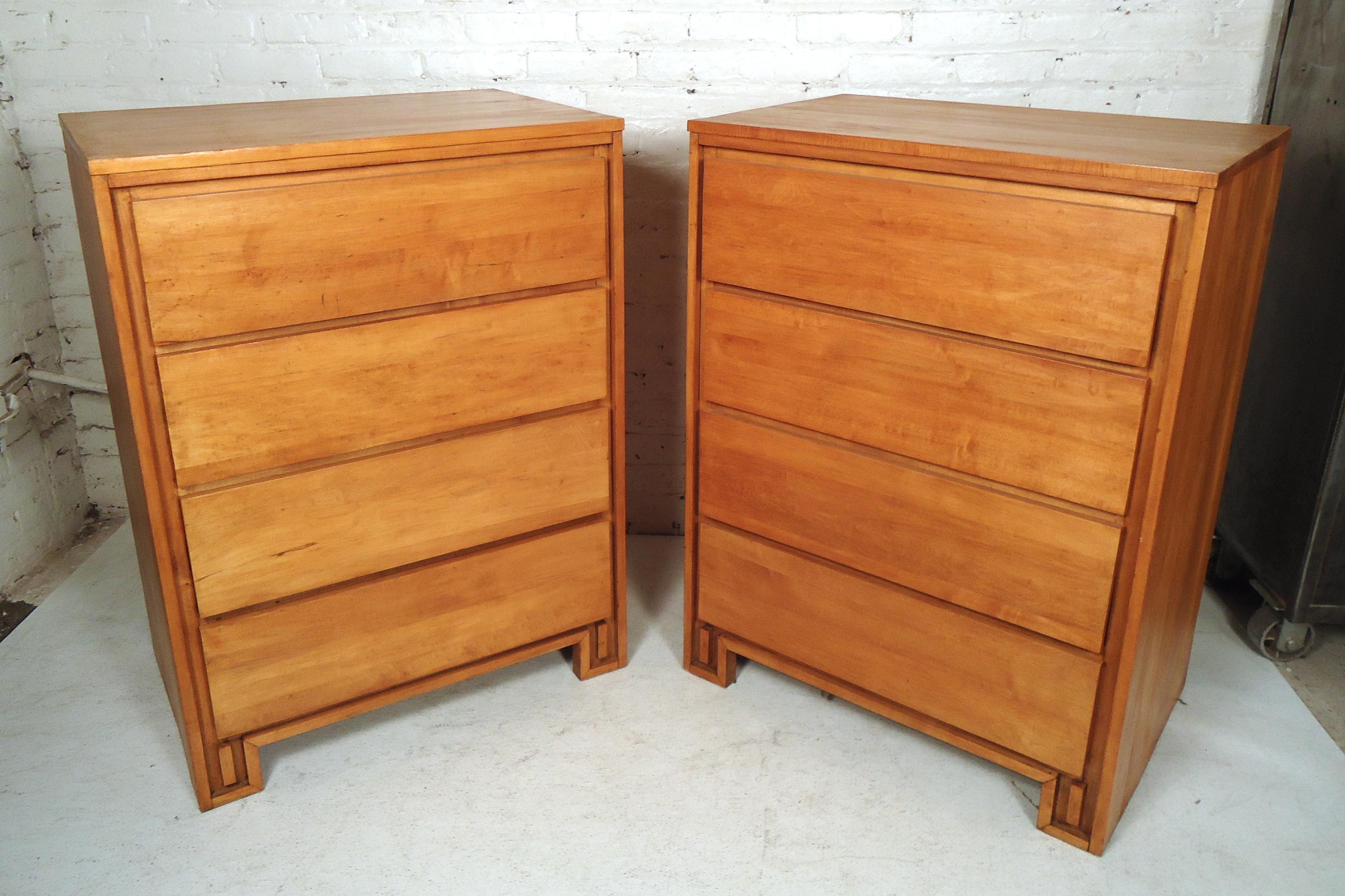 Gorgeous pair of Mid-Century Modern high boy dressers featuring maple wood grain, four drawers each, with a uniquely designed front base.

(Please confirm item location - NY or NJ - with dealer).