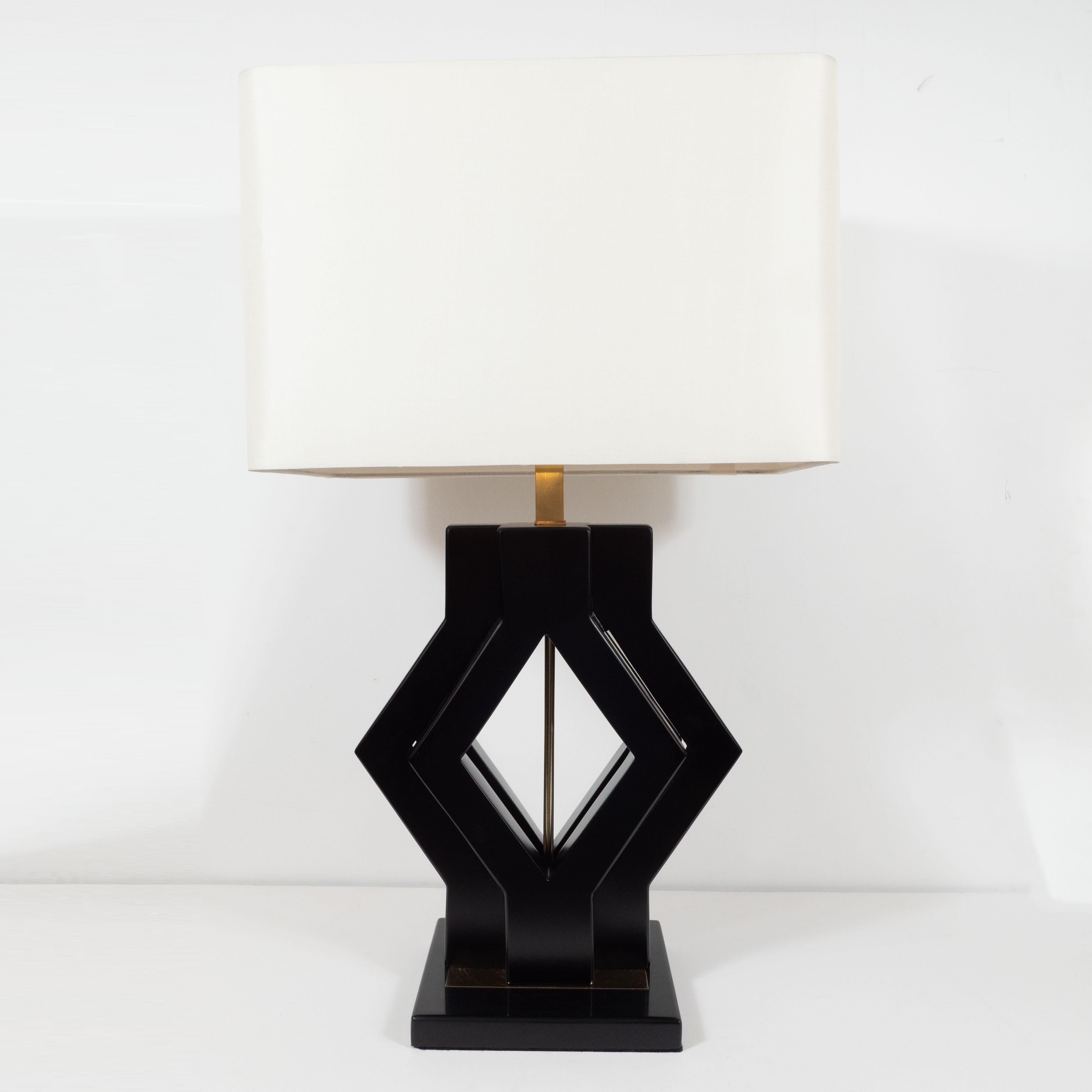 These stunning and graphic table lamps were realized in the United States, circa 1970. They feature a square ebonized walnut base with a central polished brass plate from which two concentric diamond forms, also in ebonized walnut rise upwards. A