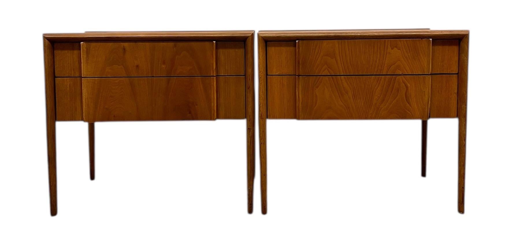 Offered here is a pair of mid-century modern end tables from the Parallel collection by Drexel. Each table features two spacious drawers with clean, sculpted front panels and recessed pulls, characteristic of Drexel's refined modernist aesthetic.